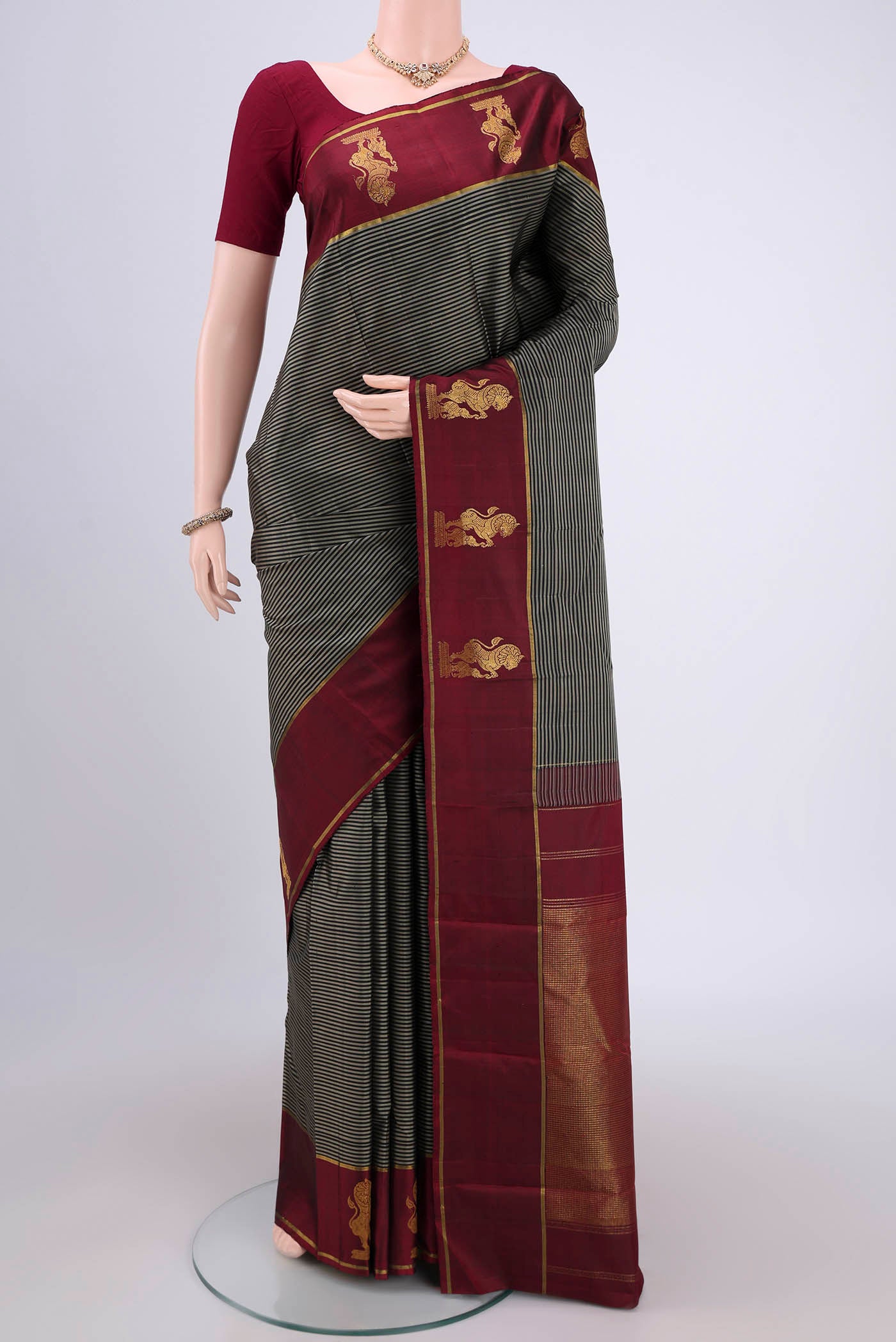 Black Kanchipuram Silk Saree with Stripes on the body and Attached Border.  displayed on a mannequin