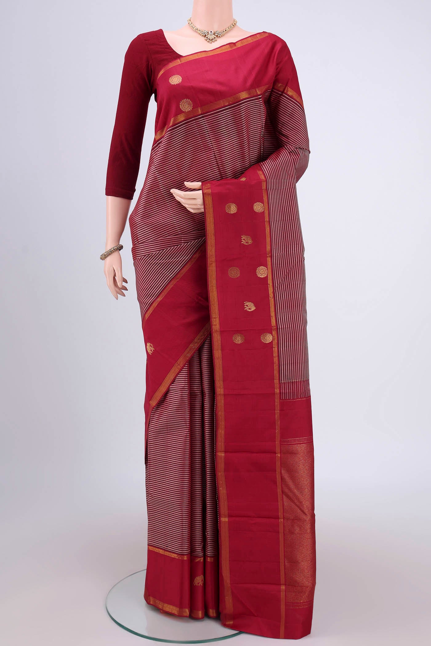 Maroon Dual Tone Kanchipuram Silk Saree with Stripes on the body and Attached Border.  displayed on a mannequin
