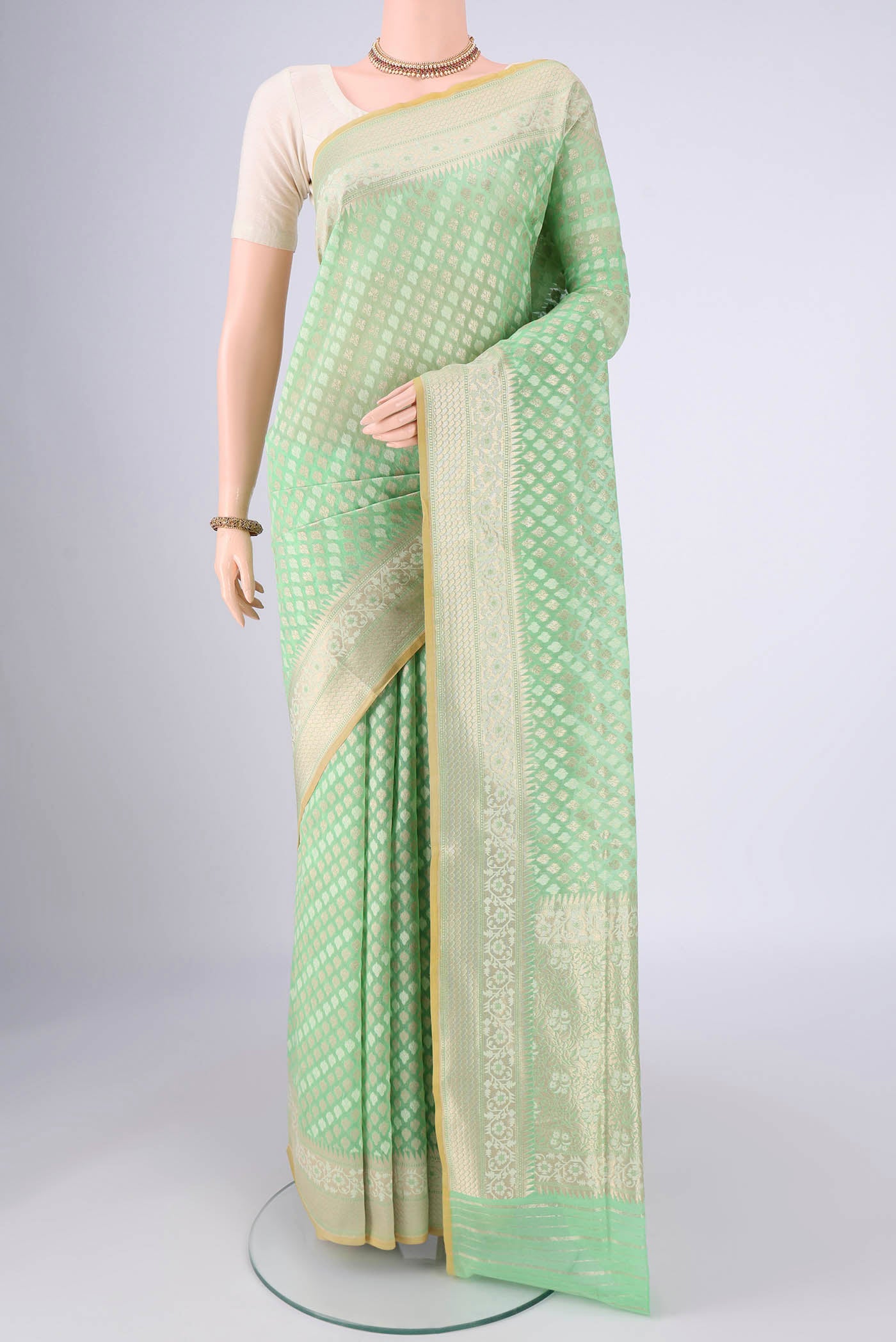 Light Green Banarasi Silk Saree with Jacquard With Zari Butta on the body and Zari And Thread Border.  displayed on a mannequin