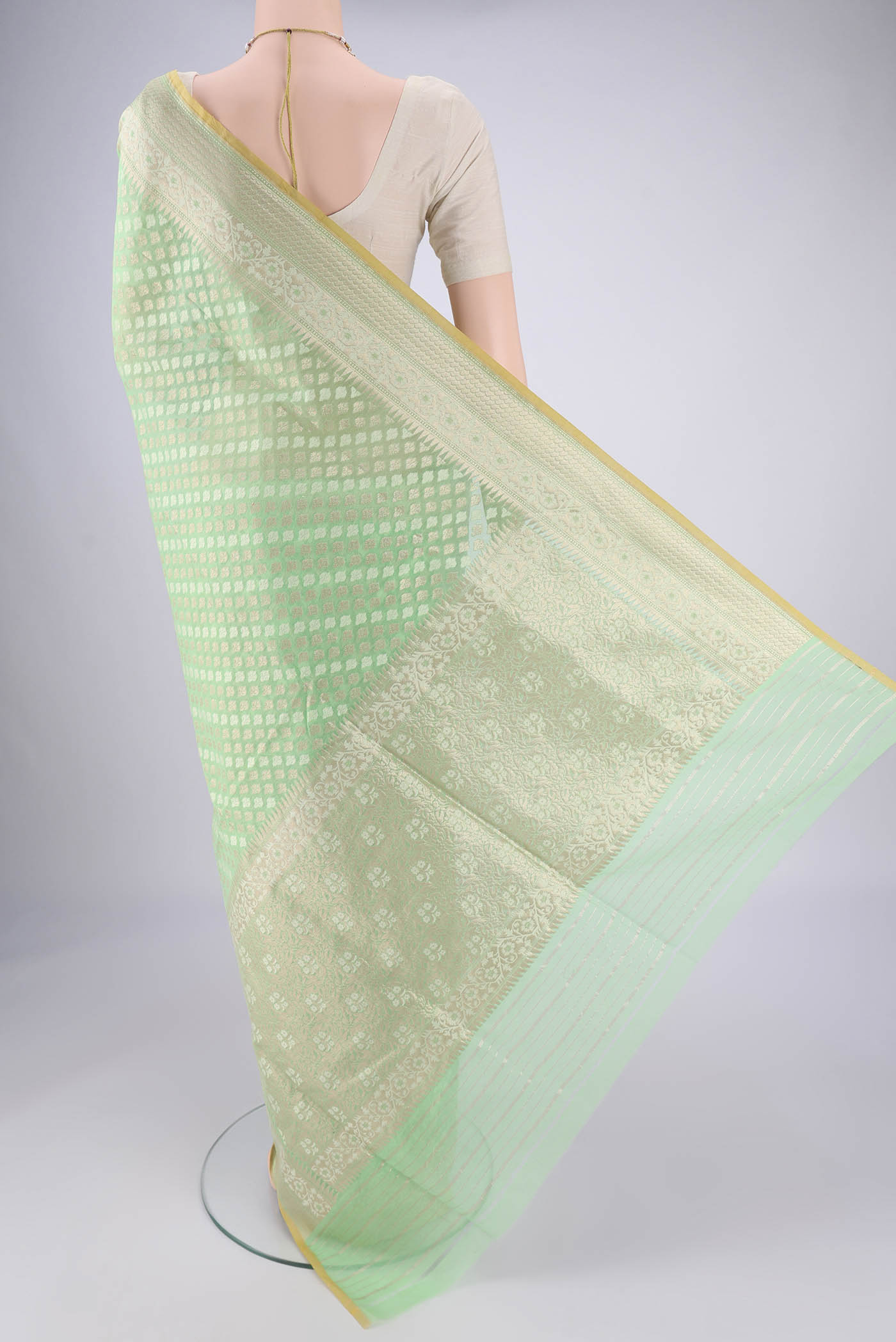 Flat view of Light Green Banarasi Silk Saree with Jacquard With Zari Butta on the body and Zari And Thread Border. 