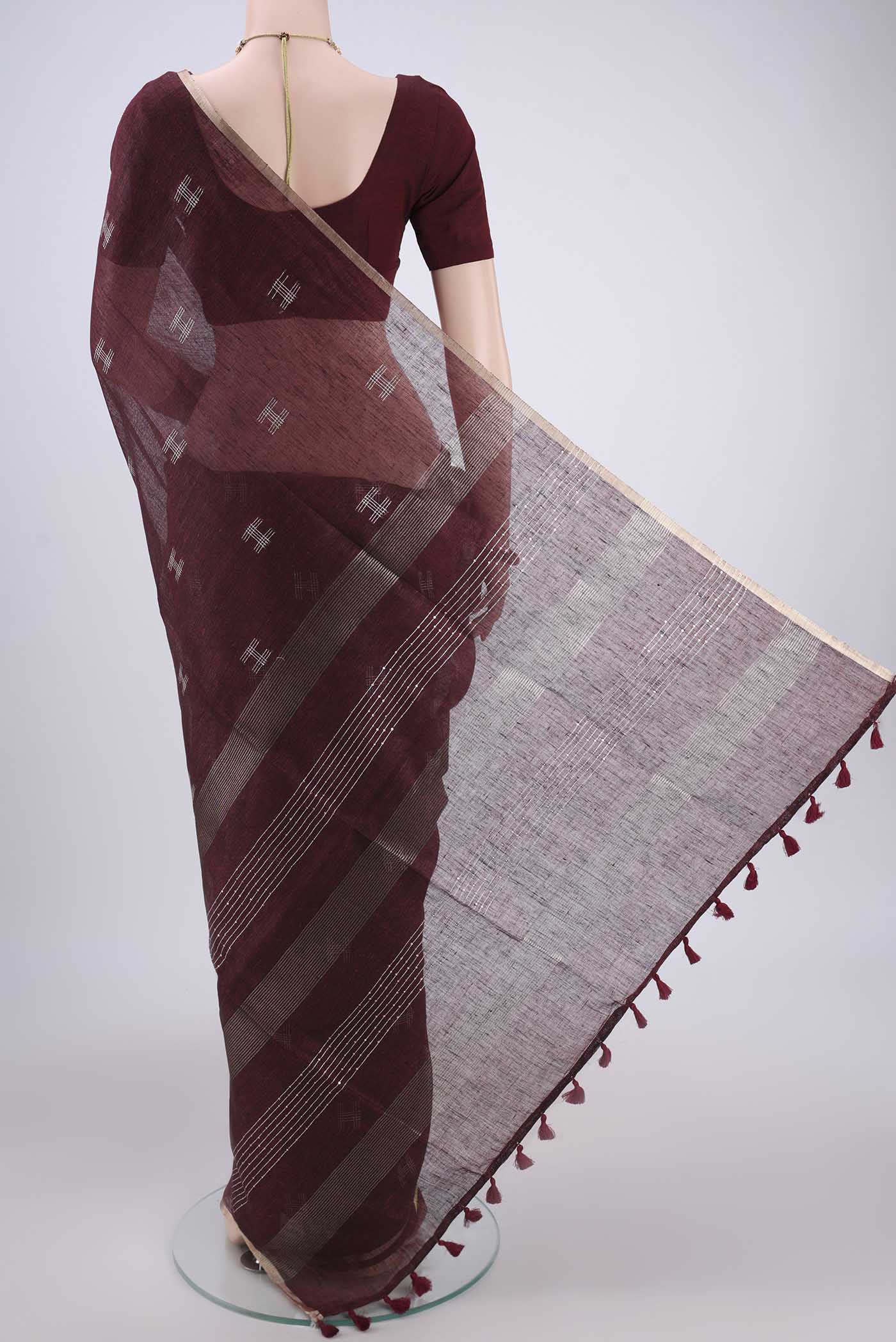 Flat view of Maroon Blended Linen Saree with Thread Butta on the body and Zari Border. 