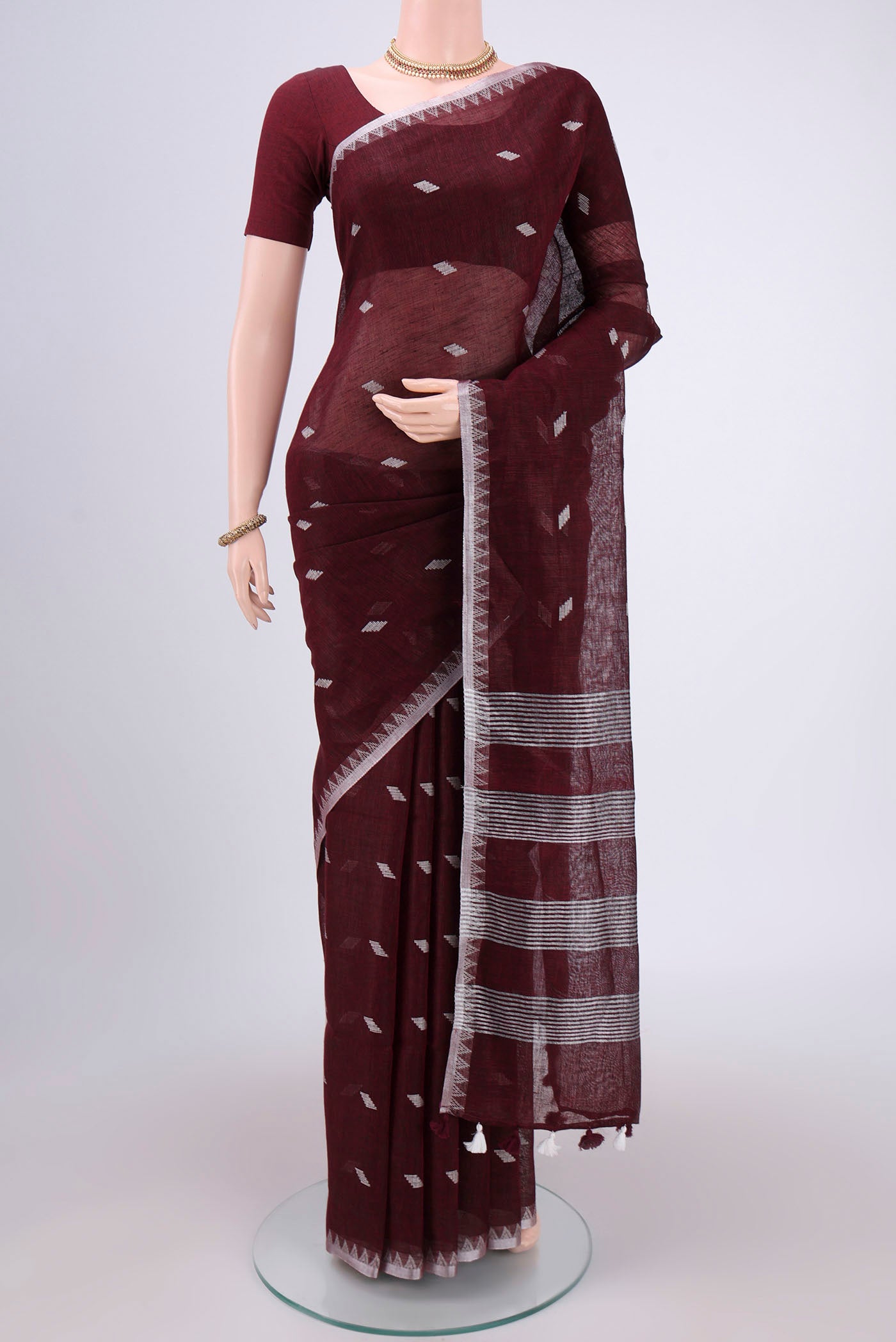 Maroon Blended Linen Saree with Thread Butta on the body and Zari Border.  displayed on a mannequin