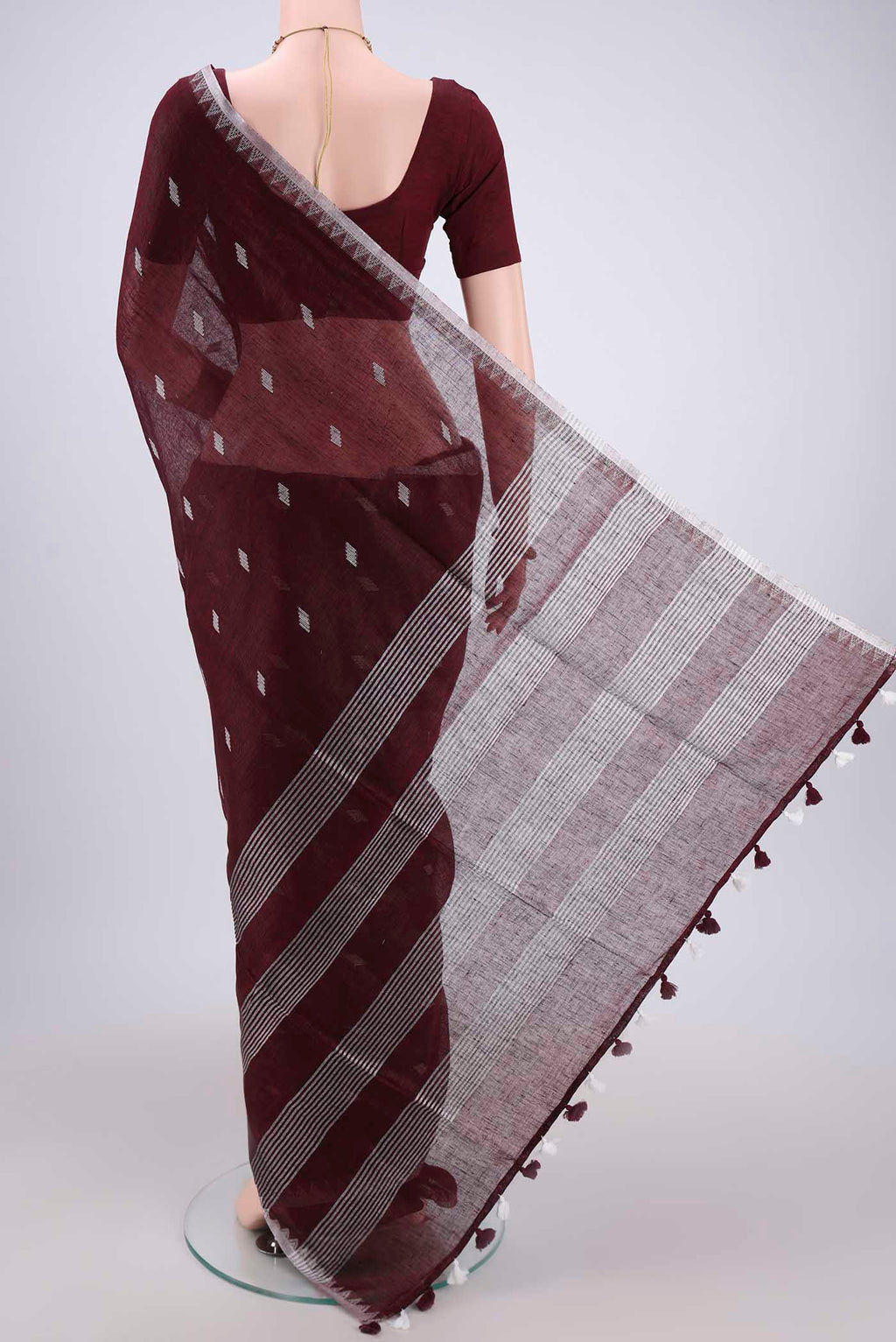 Flat view of Maroon Blended Linen Saree with Thread Butta on the body and Zari Border. 