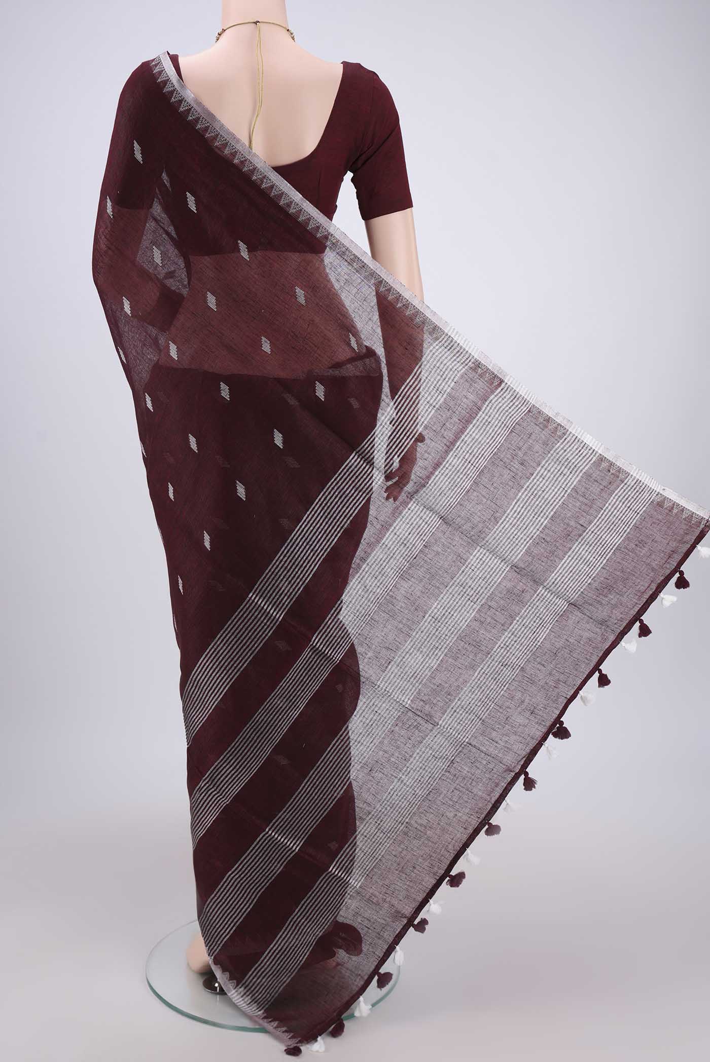 Flat view of Maroon Blended Linen Saree with Thread Butta on the body and Zari Border. 