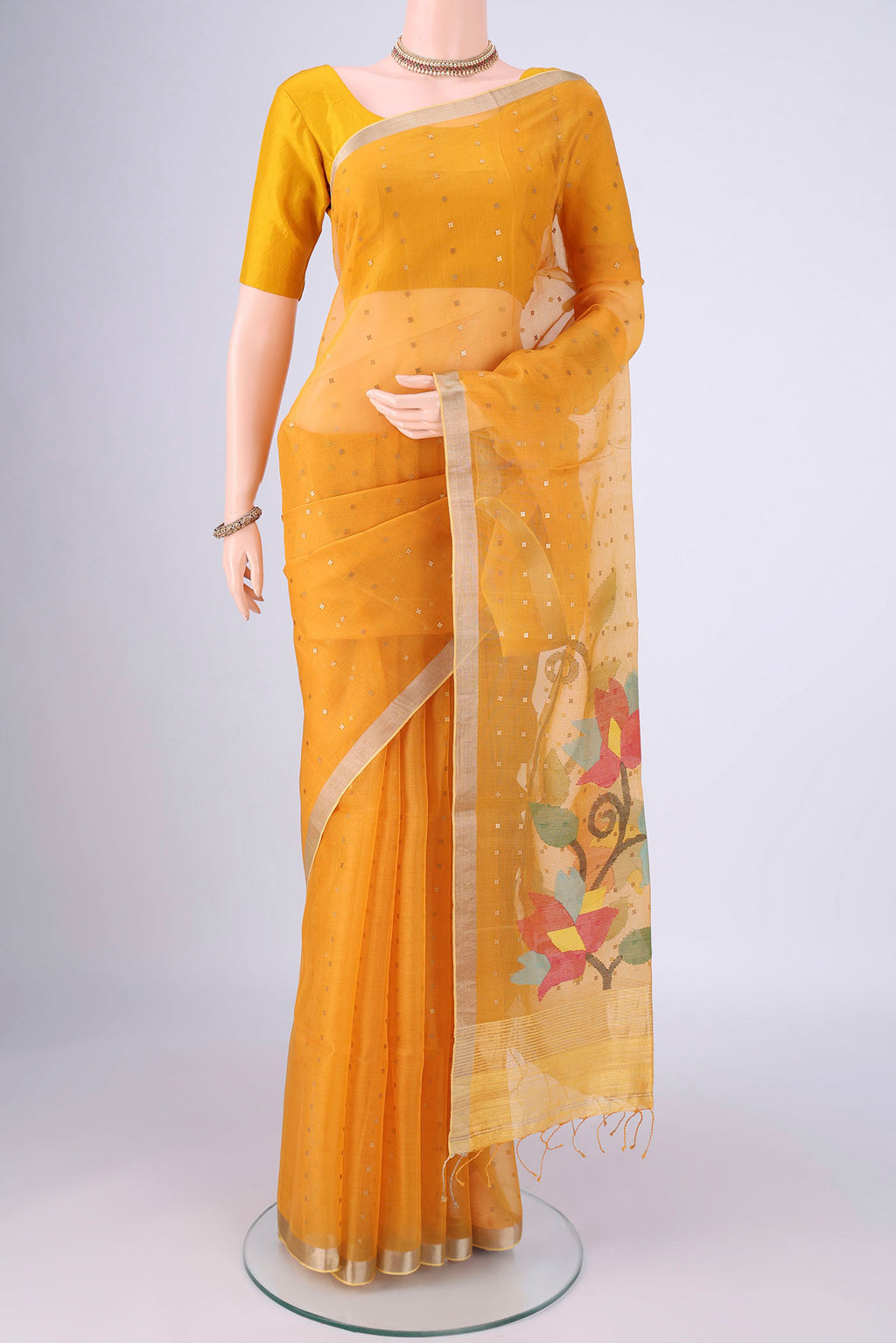 Yellow Muslin Silk Saree with Embroidery on the body and Zari Border.  displayed on a mannequin