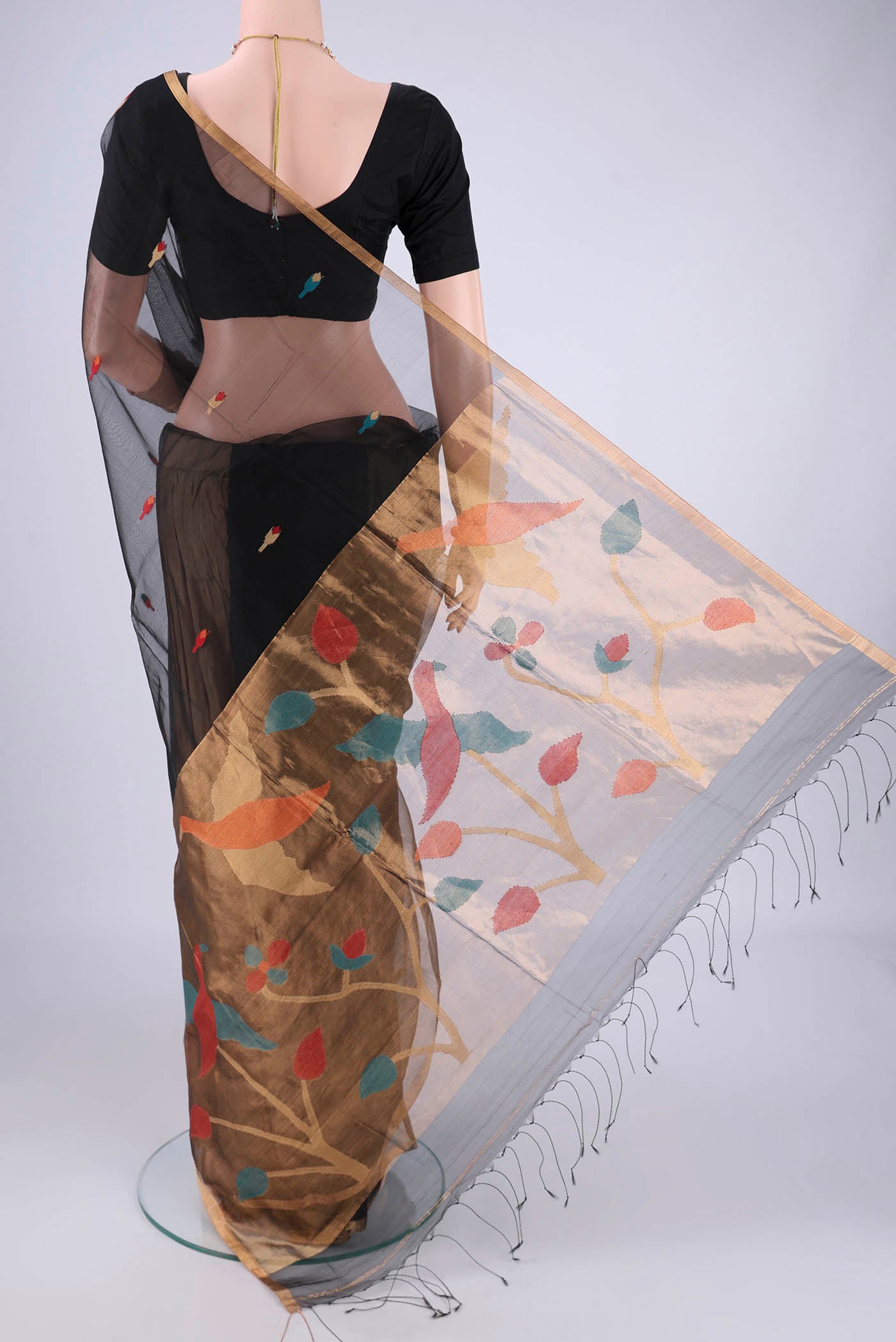 Flat view of Black Muslin Silk Saree with Jamdani on the body and Zari Border. 