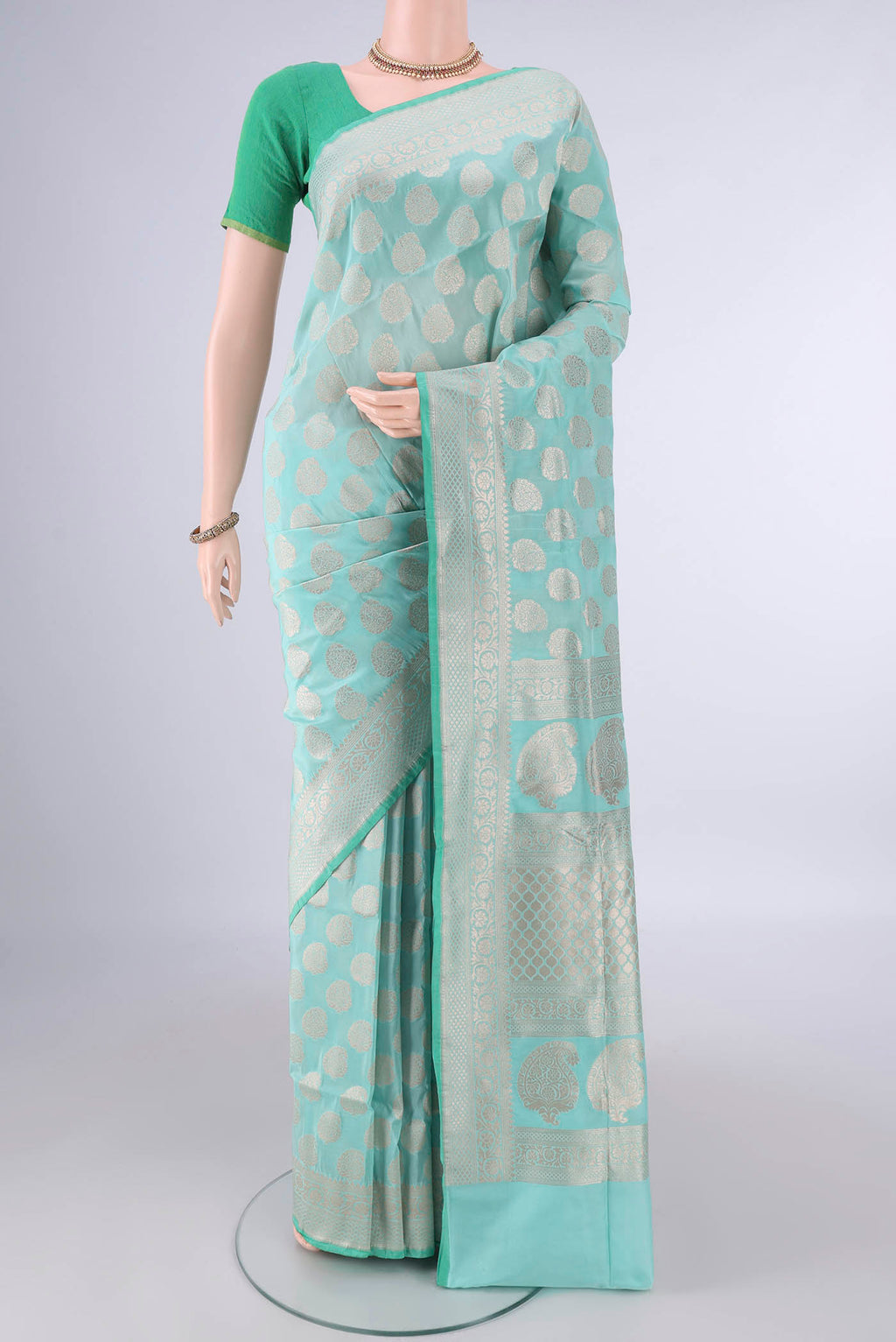 Pure Silk Mint Green Banarasi Saree with Zari Butta on the body and Zari Border.  displayed on a mannequin