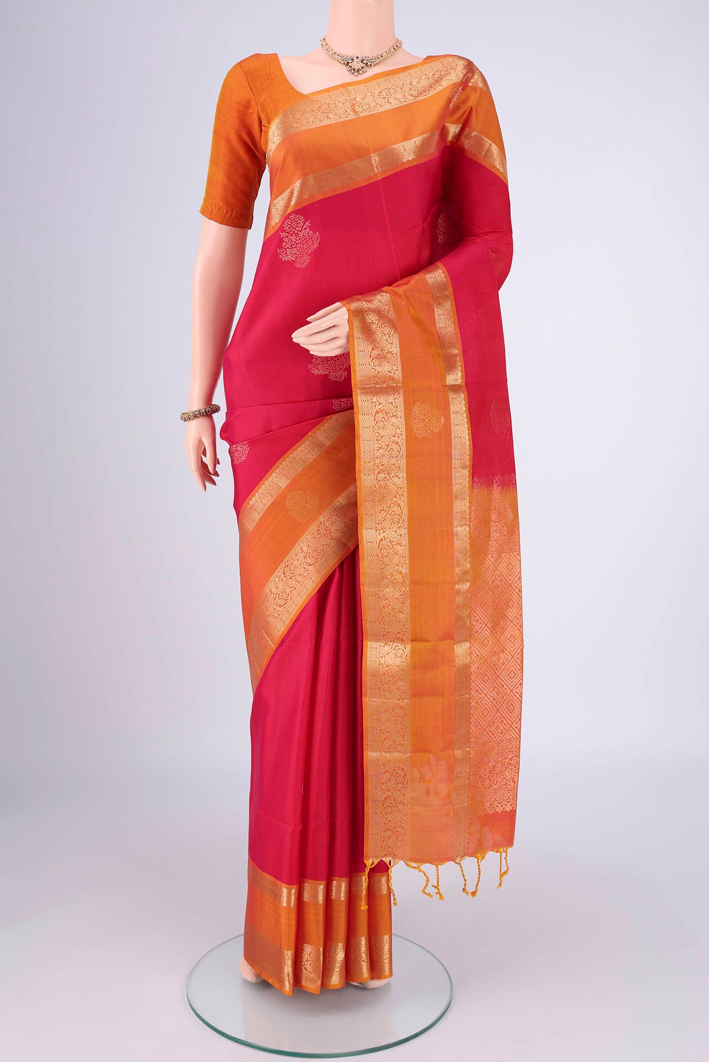 Rani Pink Soft Silk Saree with Zari Butta on the body and Zari Border.  displayed on a mannequin