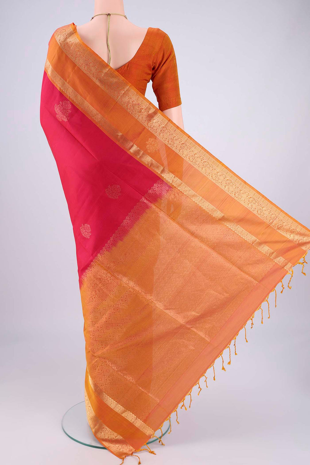 Flat view of Rani Pink Soft Silk Saree with Zari Butta on the body and Zari Border. 