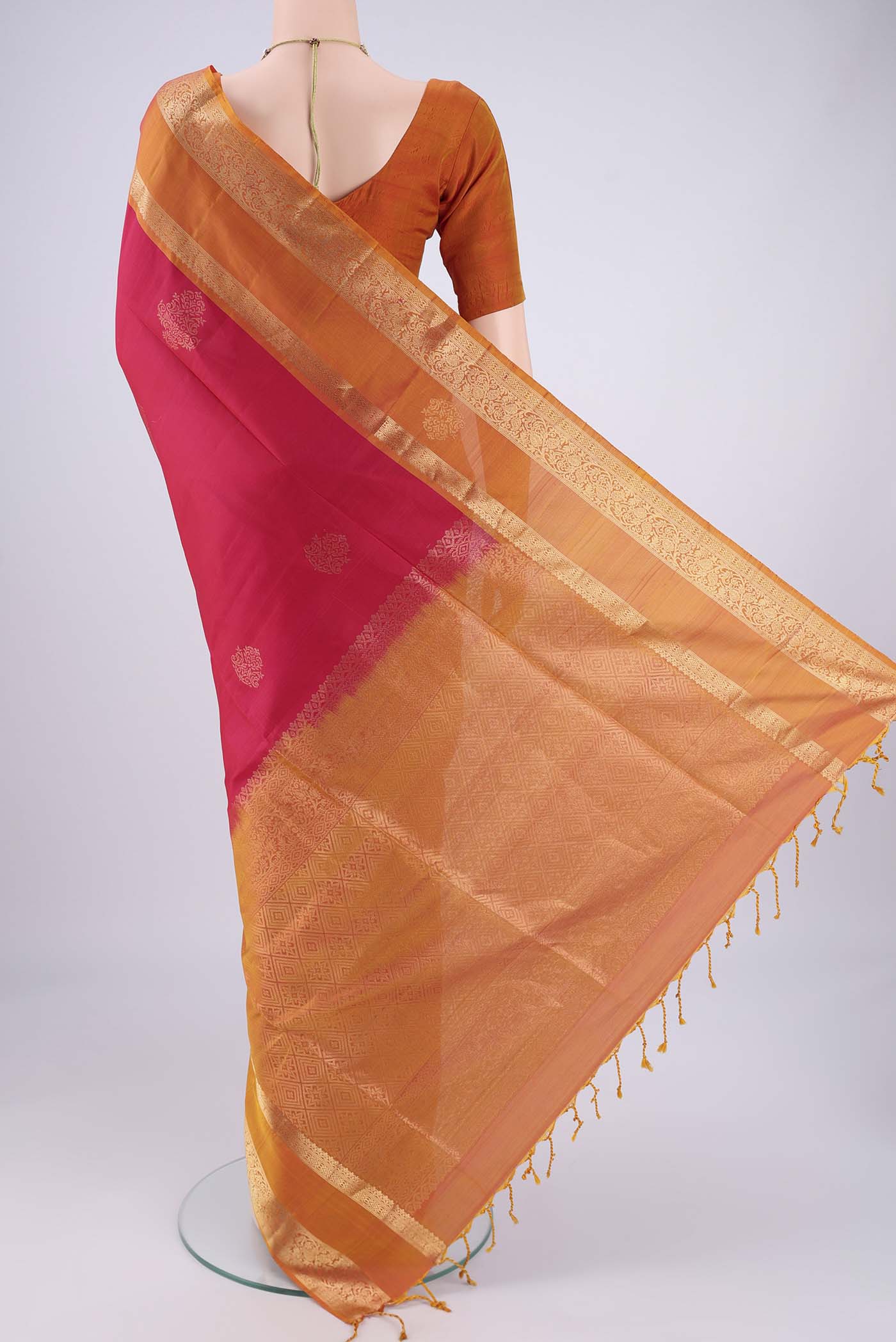 Flat view of Rani Pink Soft Silk Saree with Zari Butta on the body and Zari Border. 