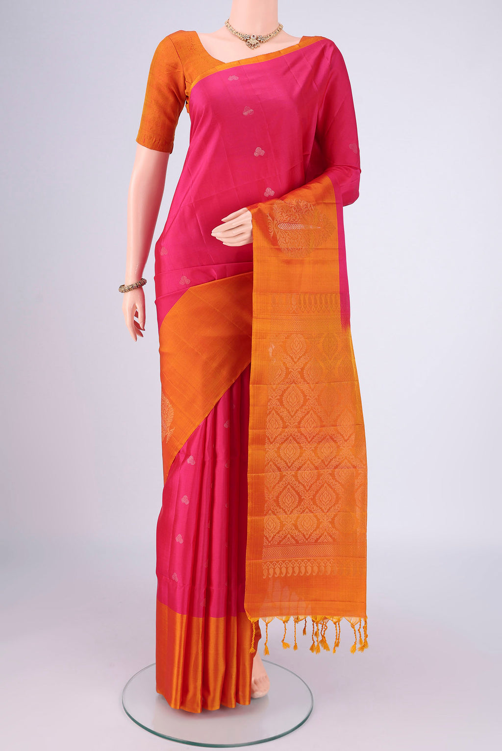 Rani Pink Soft Silk Saree with Zari Butta on the body and Plain Border.  displayed on a mannequin
