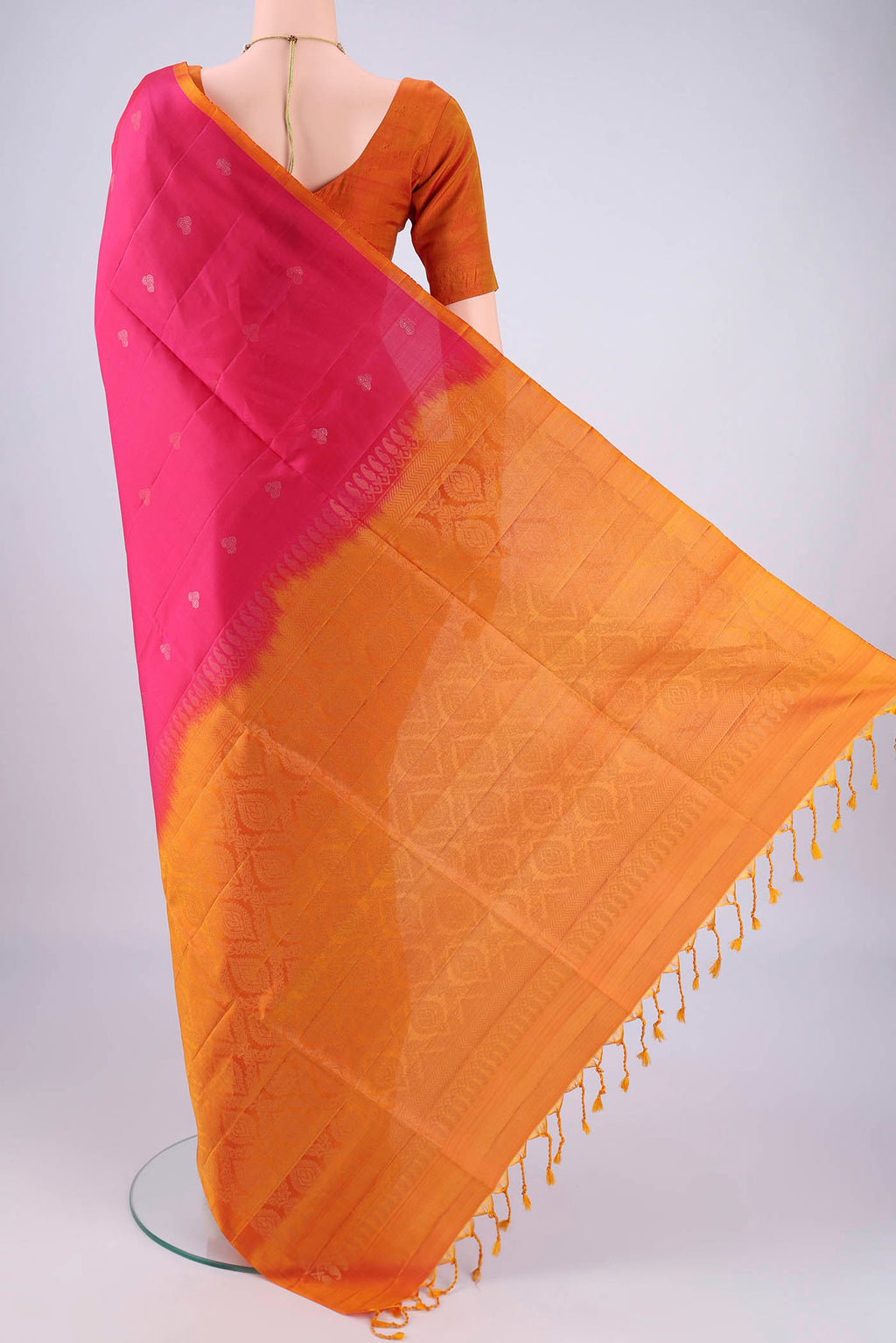 Flat view of Rani Pink Soft Silk Saree with Zari Butta on the body and Plain Border. 