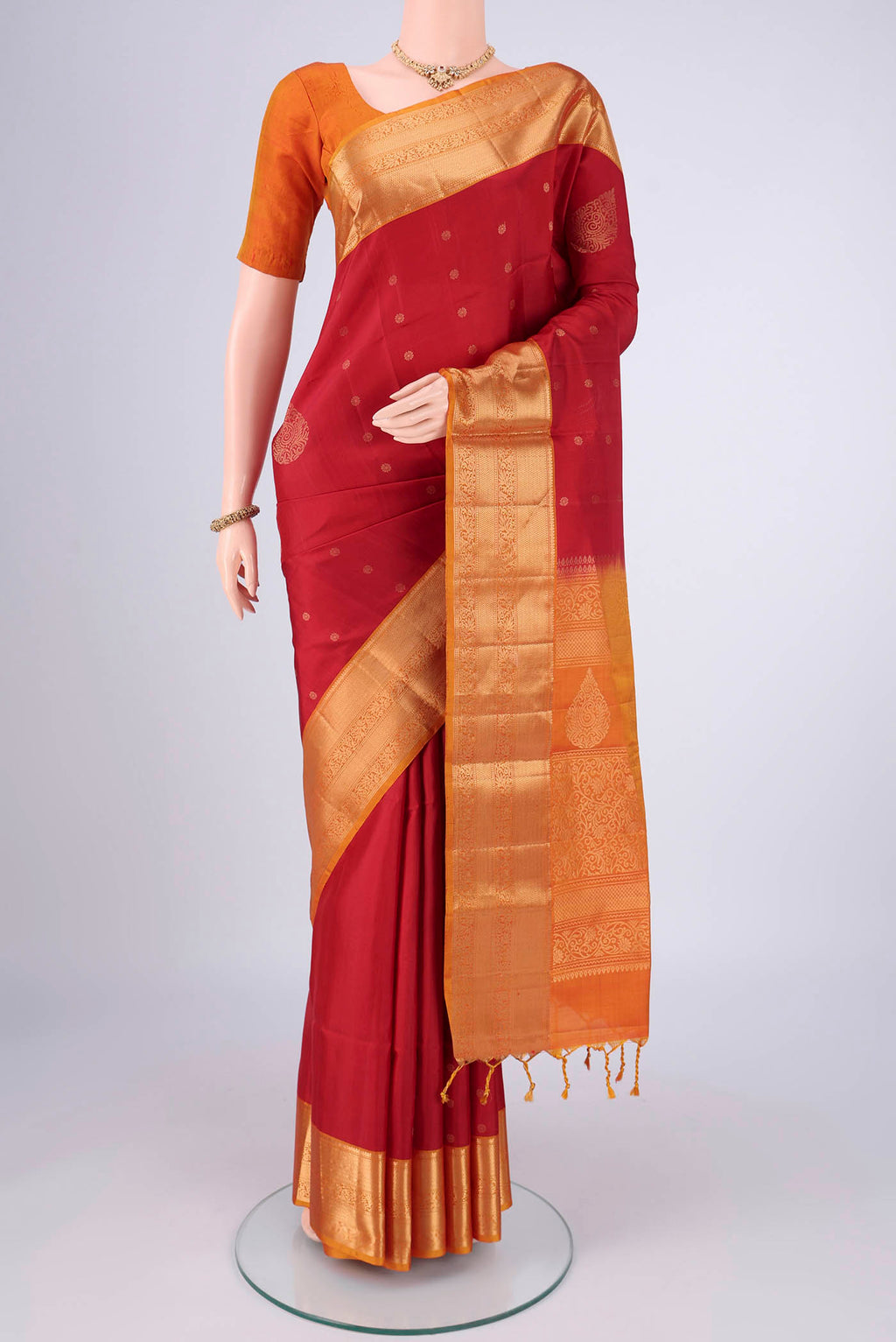 Maroon Soft Silk Saree with Zari Butta on the body and Zari Border.  displayed on a mannequin