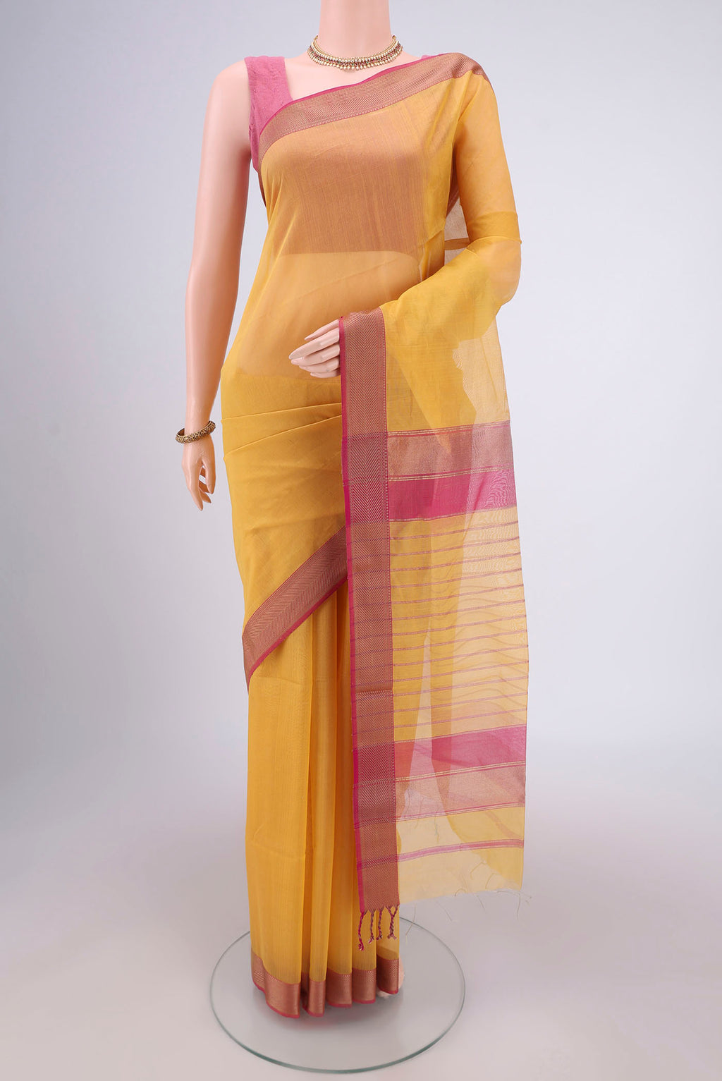 Mustard Maheshwari Silk Cotton Saree with Plain Body and Zari Border.  displayed on a mannequin