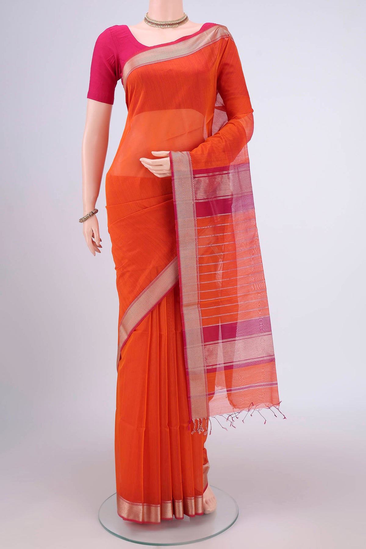 Orange Maheshwari Silk Cotton Saree with Plain Body and Thread Border.  displayed on a mannequin