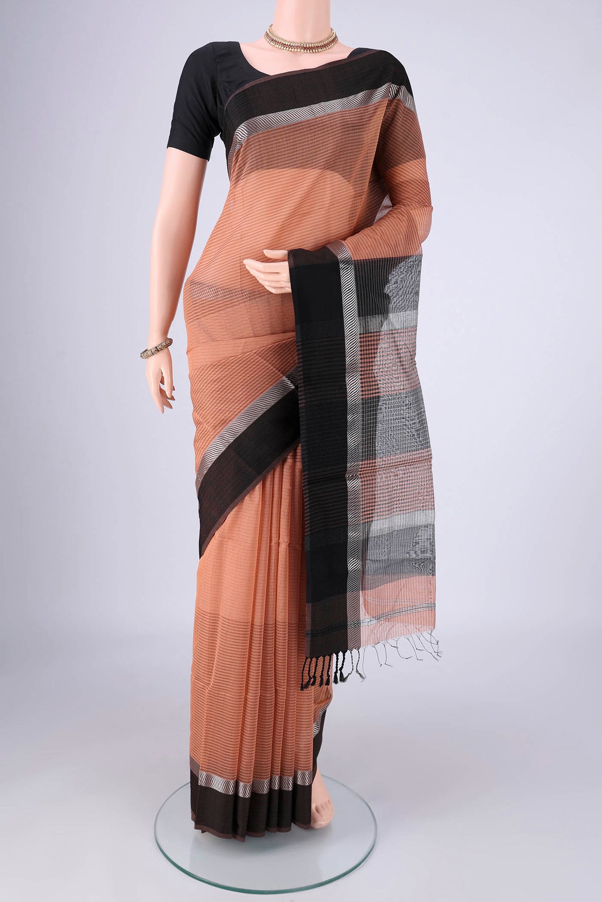 Peach Maheshwari Silk Cotton Saree with Stripes on the body and Thread Border.  displayed on a mannequin
