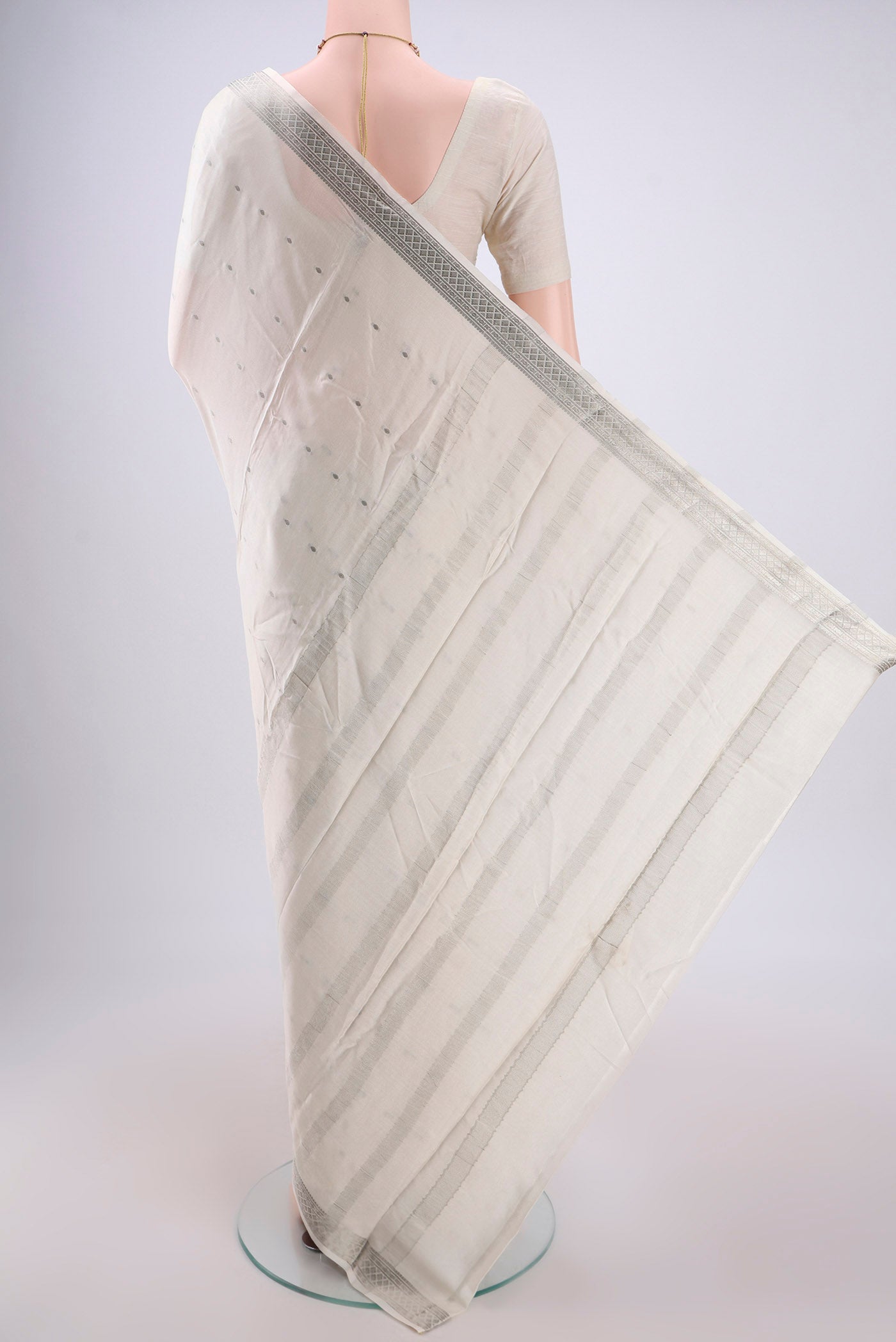 Flat view of White Mysore Crepe Saree with Zari Butta on the body and Zari Border. 