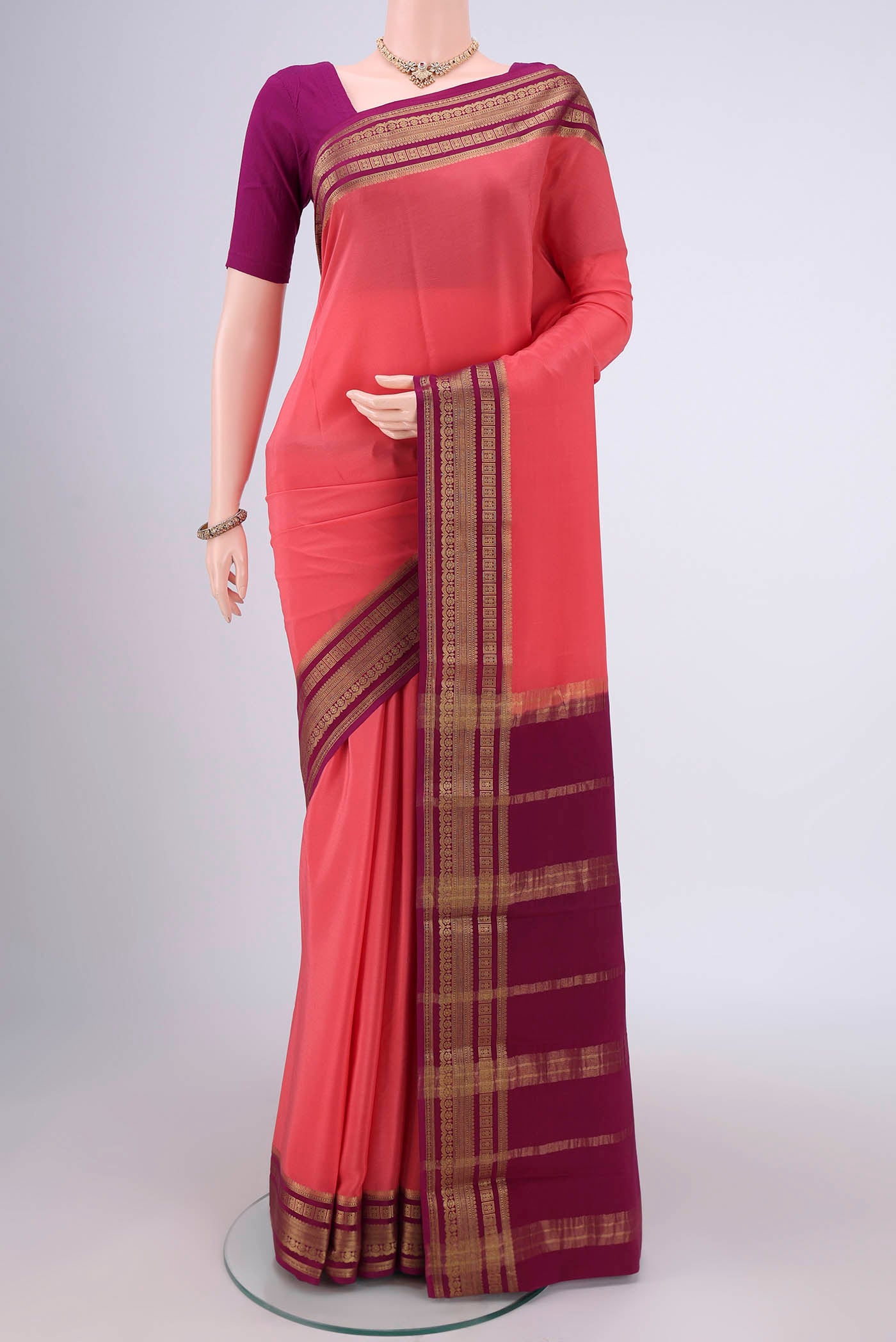 Peach Mysore Crepe Saree with Plain Body and Zari Border.  displayed on a mannequin