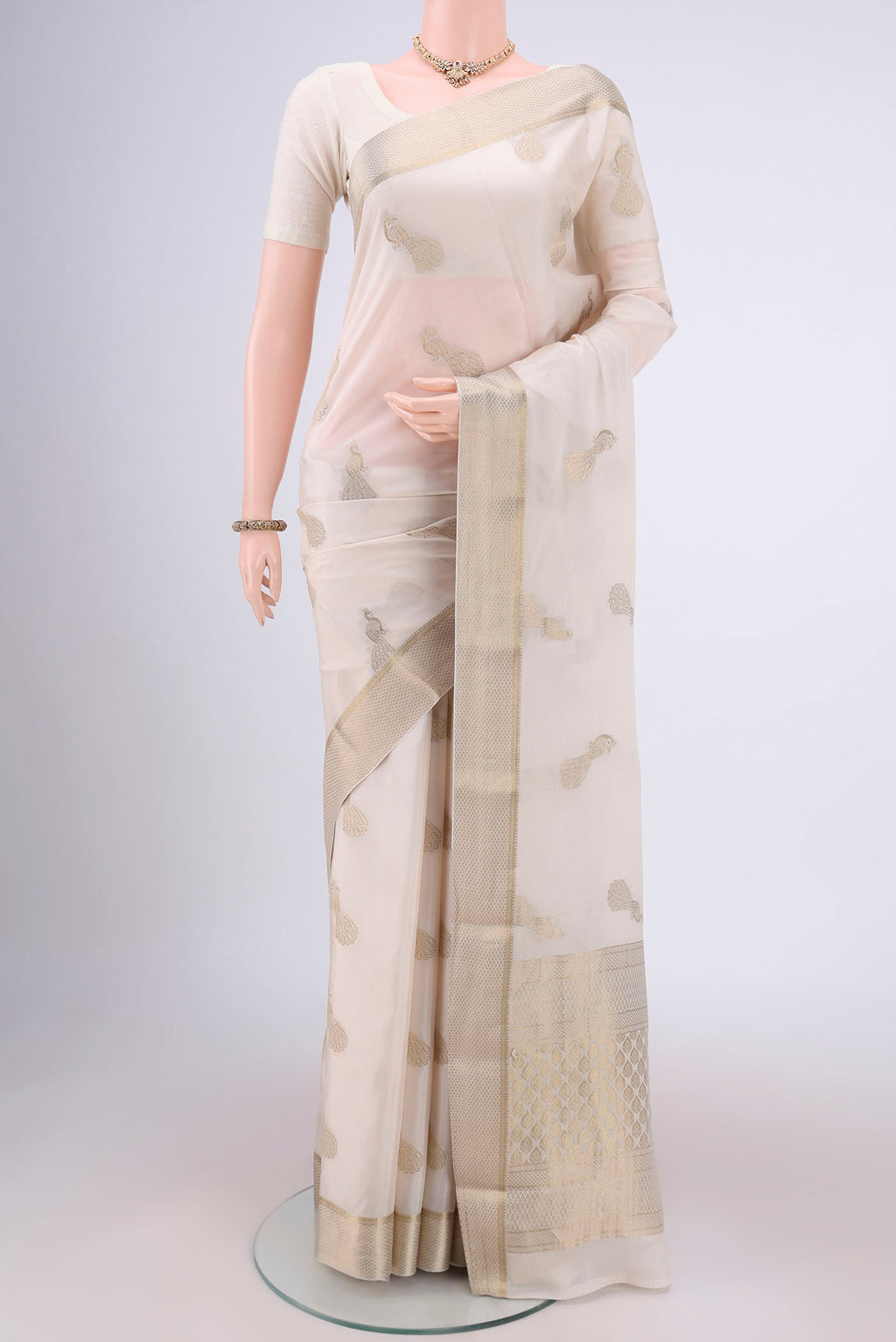Off White Mysore Crepe Saree with Zari Butta on the body and Zari Border.  displayed on a mannequin