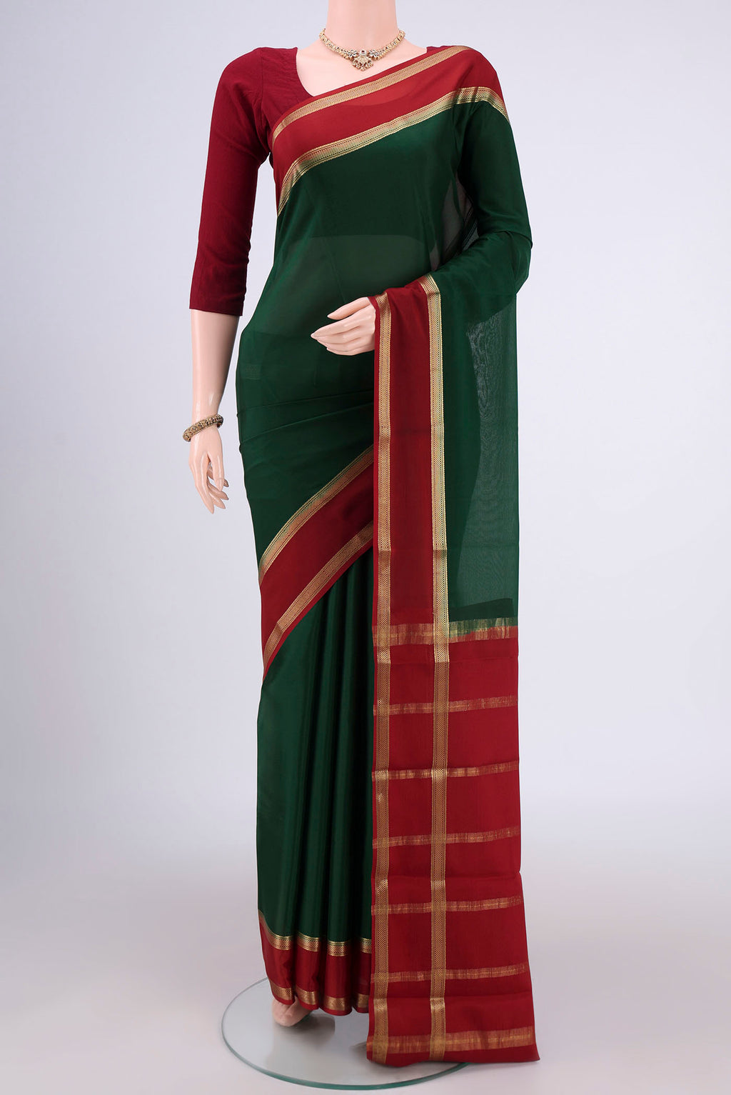 Bottle Green Mysore Crepe Saree with Plain Body and Zari Border.  displayed on a mannequin