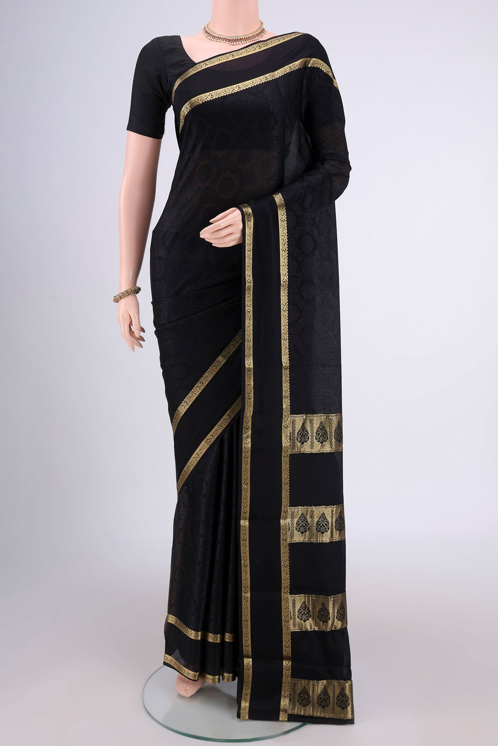 Black Mysore Crepe Saree with Jacquard design on the body and Zari Border.  displayed on a mannequin