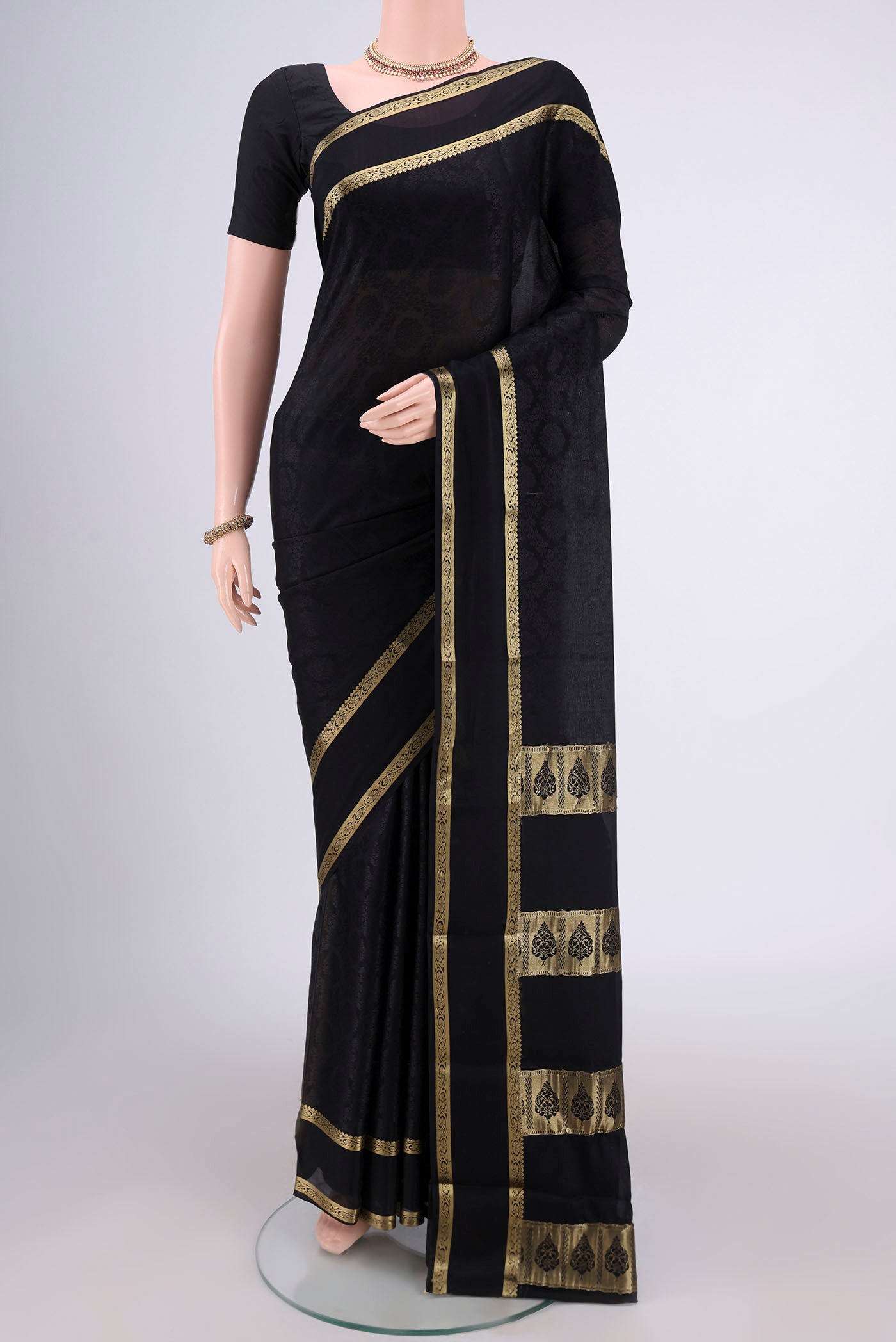 Black Mysore Crepe Saree with Jacquard design on the body and Zari Border.  displayed on a mannequin