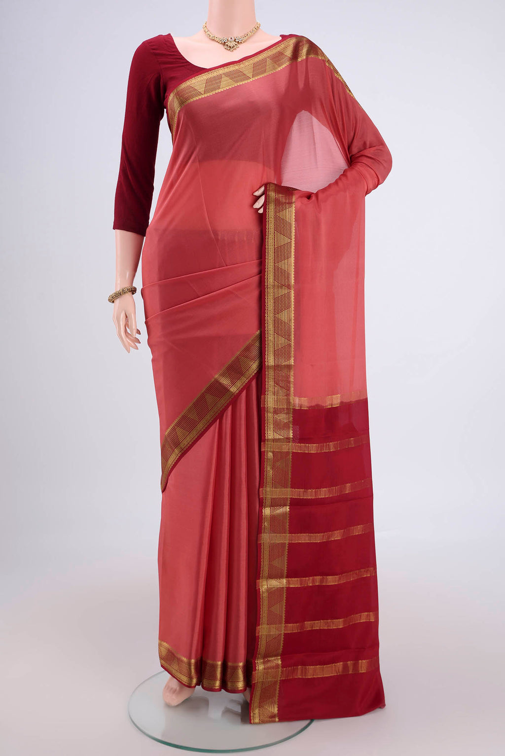 Coral Mysore Crepe Saree with Plain Body and Zari Border.  displayed on a mannequin
