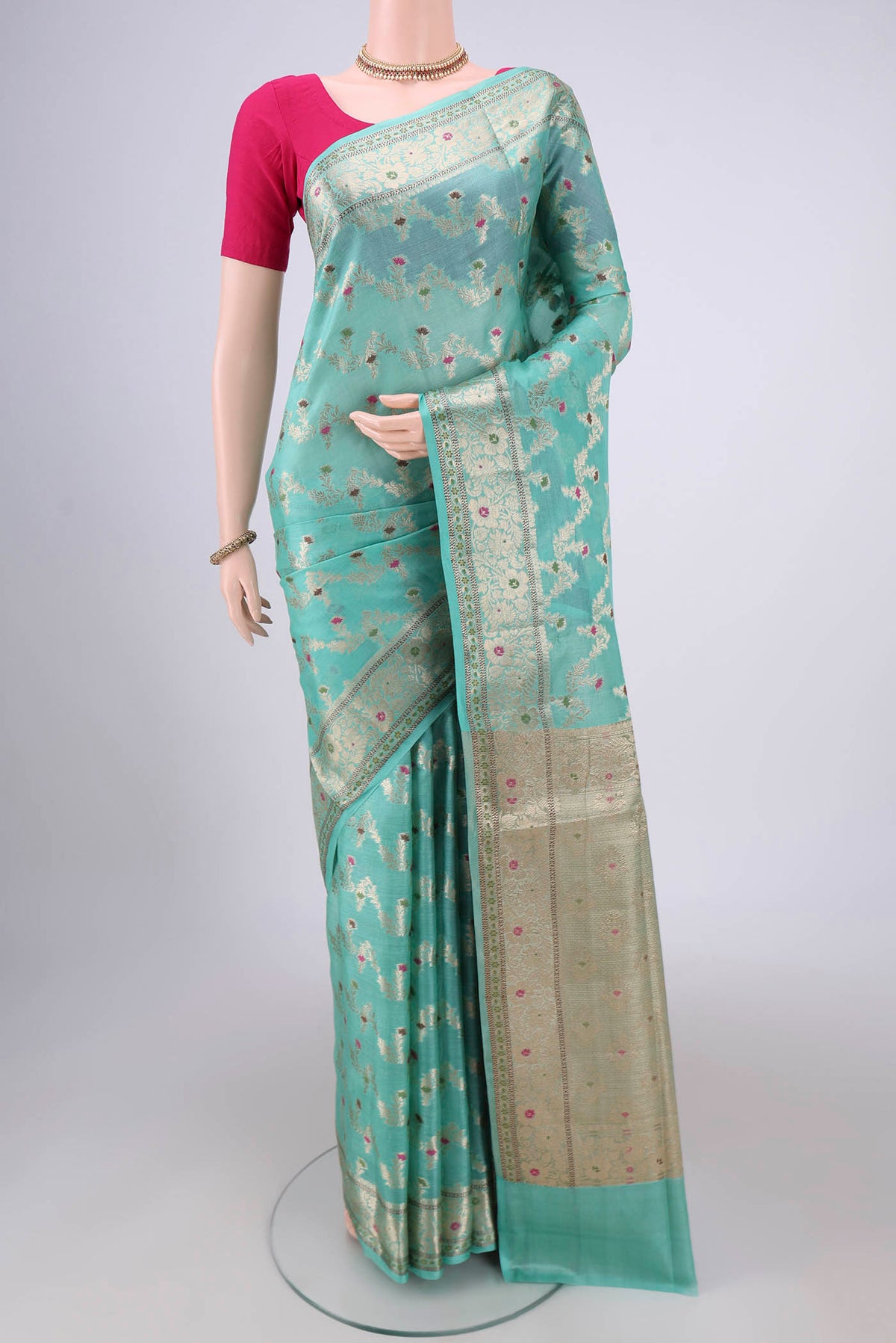 Mint Green Banarasi Tussar Silk Saree with Zari And Thread Butta on the body and Zari And Thread Border.  displayed on a mannequin