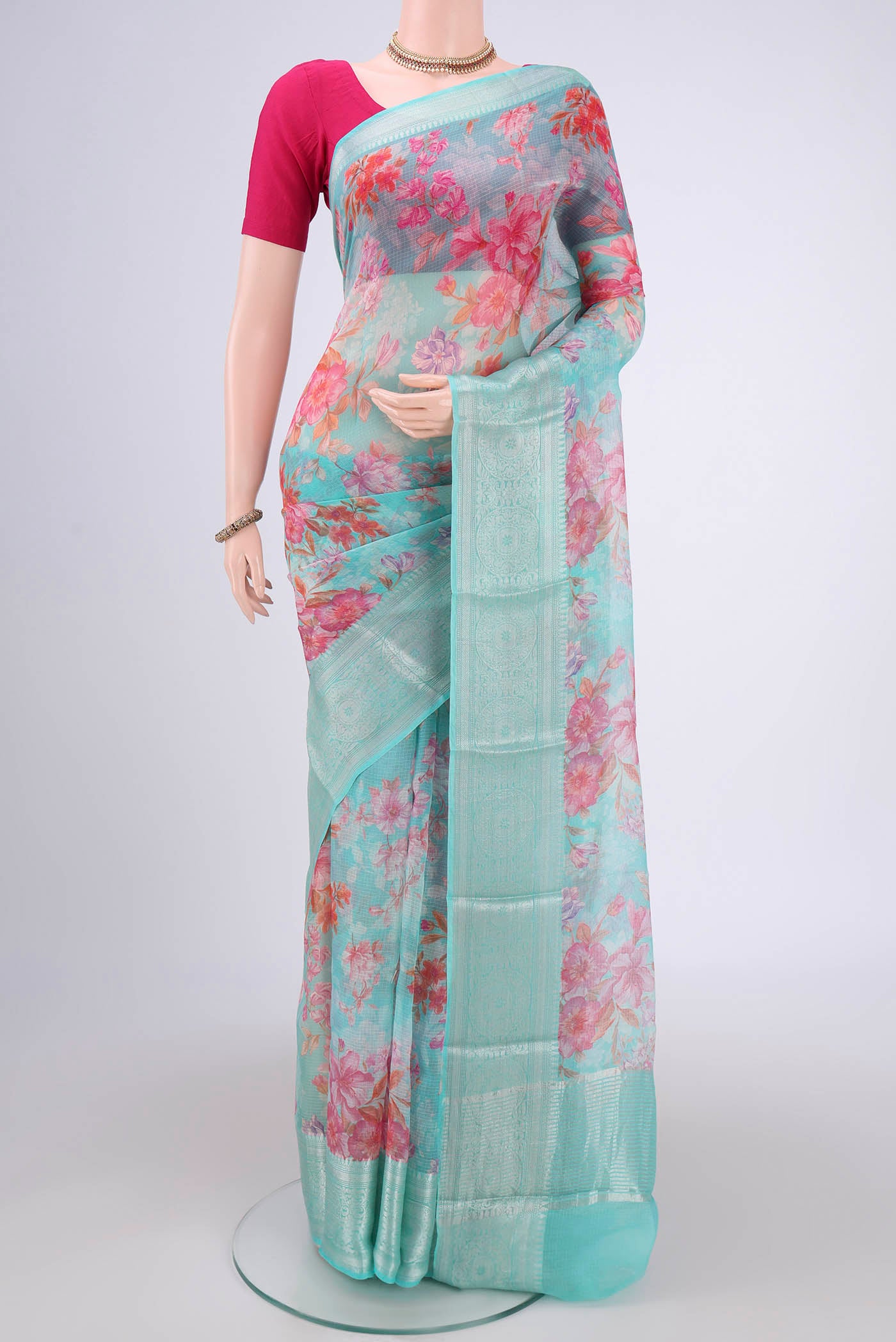 Turquoise Kota Silk Saree with Floral Print on the body and Zari Border.  displayed on a mannequin