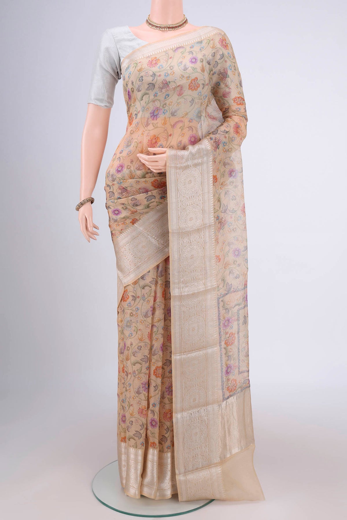 Beige Kota Silk Saree with Floral Print on the body and Zari Border.  displayed on a mannequin