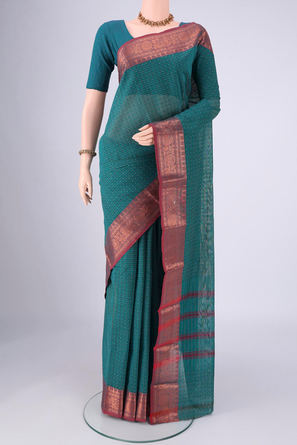 Green Kanchi Cotton Saree with Checked design on the body and Zari Border.  displayed on a mannequin