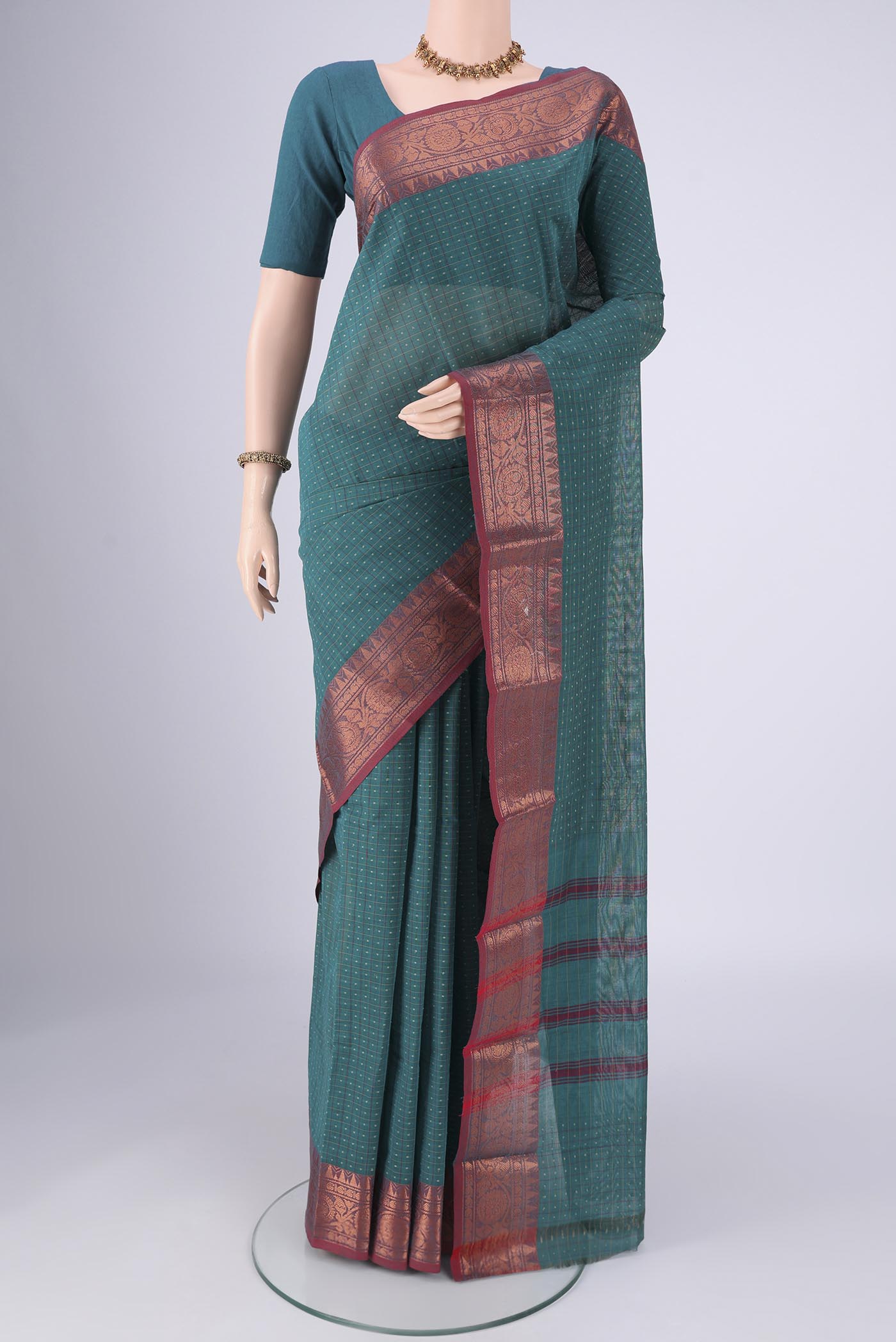 Green Kanchi Cotton Saree with Checked design on the body and Zari Border.  displayed on a mannequin