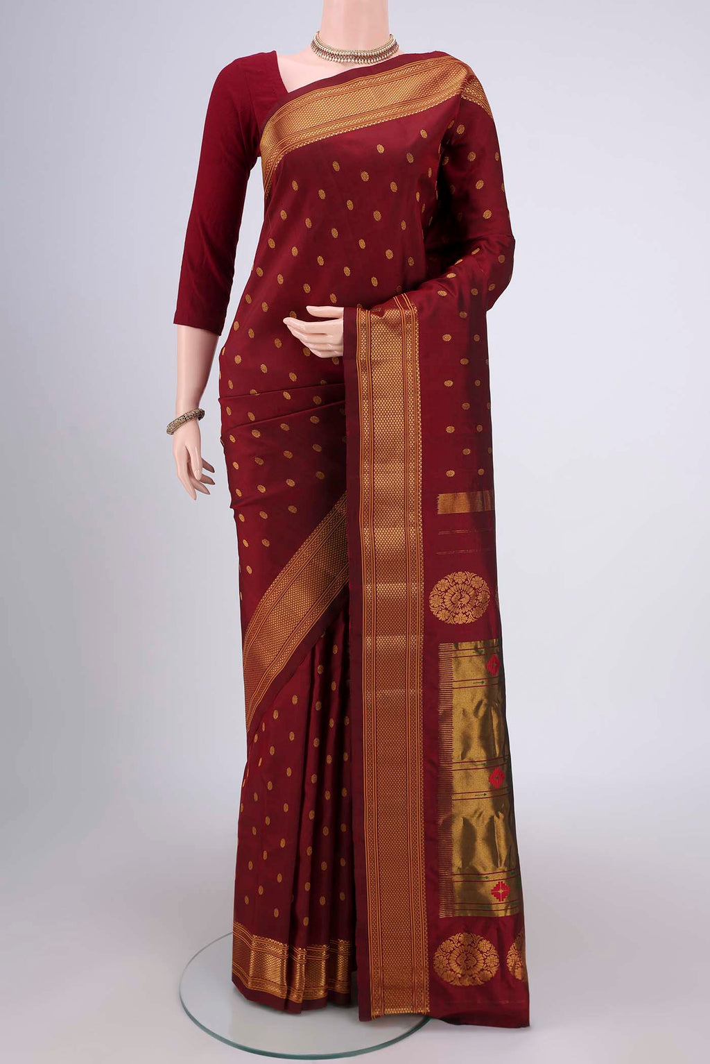 Maroon Gadwal Silk Saree with Zari Butta on the body and Zari Border.  displayed on a mannequin