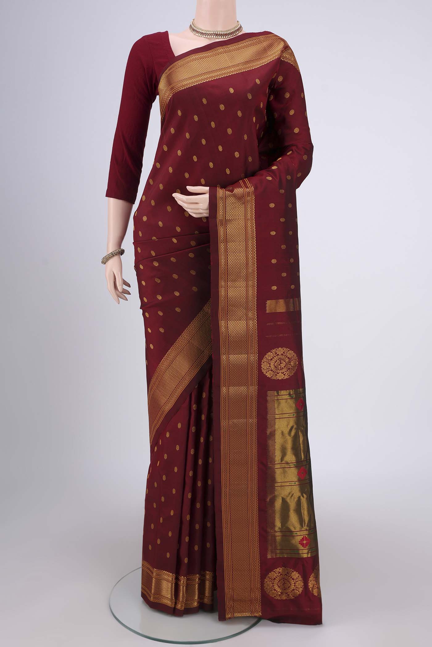 Maroon Gadwal Silk Saree with Zari Butta on the body and Zari Border.  displayed on a mannequin