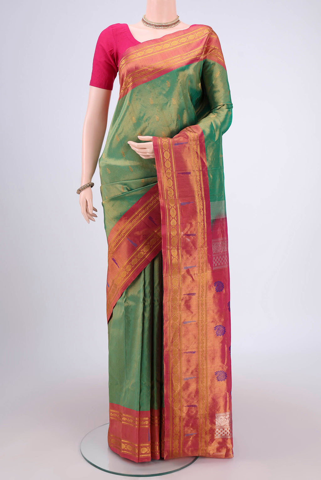 Green Gadwal Silk Saree with Zari Butta on the body and Zari Border.  displayed on a mannequin