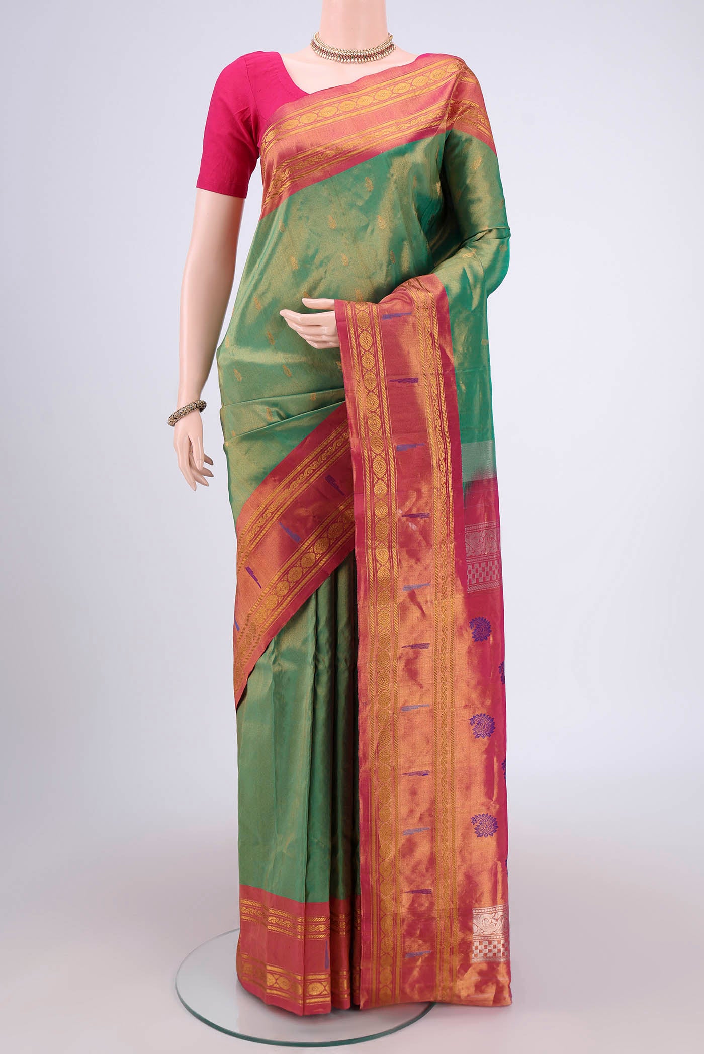 Green Gadwal Silk Saree with Zari Butta on the body and Zari Border.  displayed on a mannequin