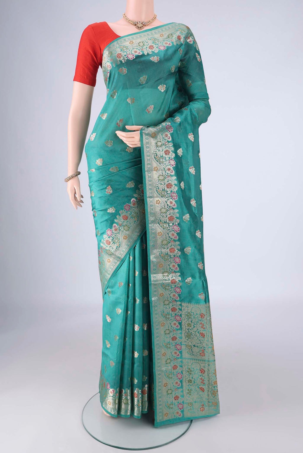 Sea Green Banarasi Raw Silk Saree with Zari And Thread Butta on the body and Zari Border.  displayed on a mannequin