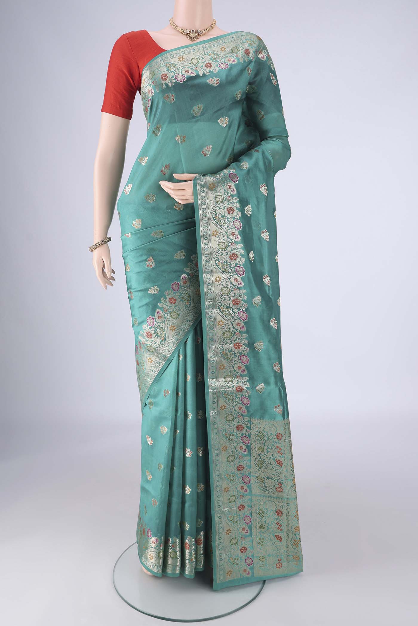 Sea Green Banarasi Raw Silk Saree with Zari And Thread Butta on the body and Zari Border.  displayed on a mannequin