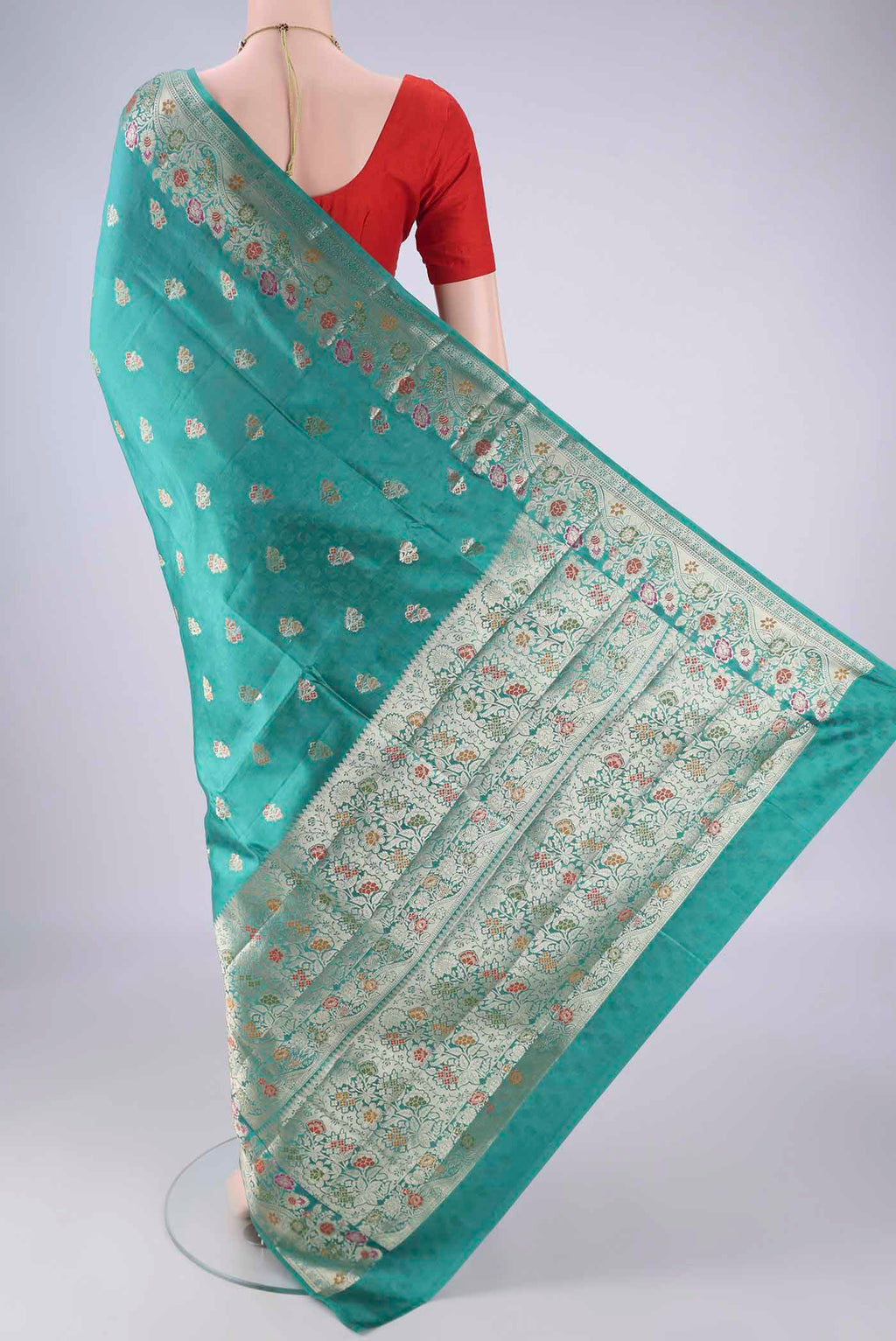 Flat view of Sea Green Banarasi Raw Silk Saree with Zari And Thread Butta on the body and Zari Border. 