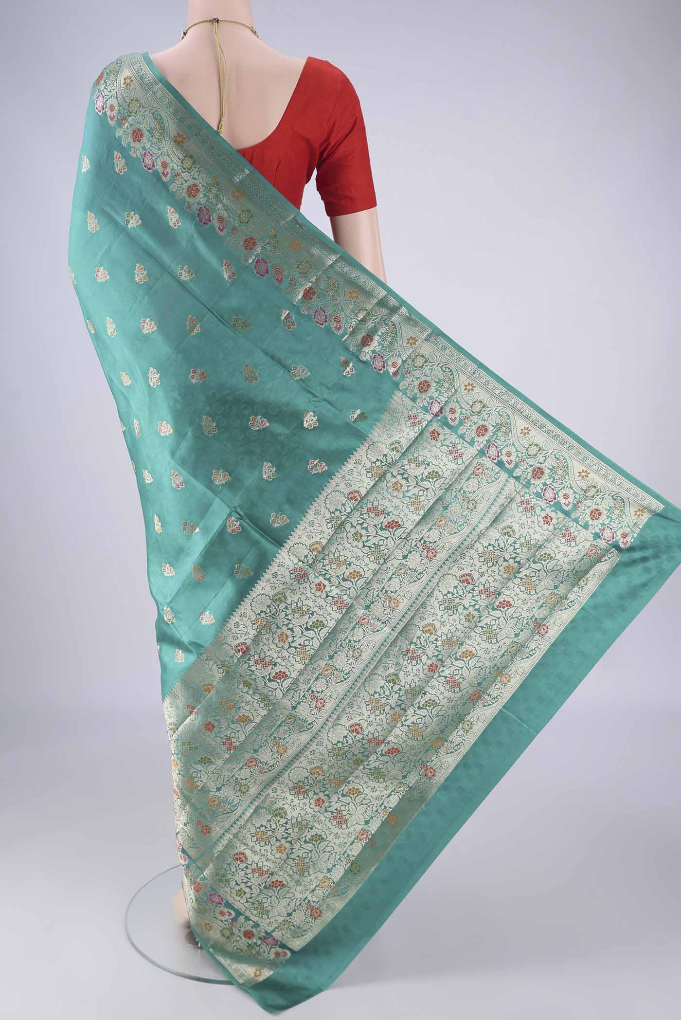 Flat view of Sea Green Banarasi Raw Silk Saree with Zari And Thread Butta on the body and Zari Border. 