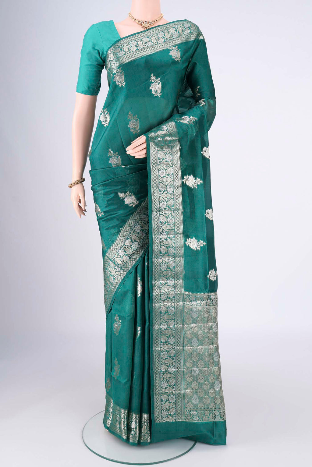 Bottle Green Banarasi Raw Silk Saree with Zari Butta on the body and Zari Border.  displayed on a mannequin