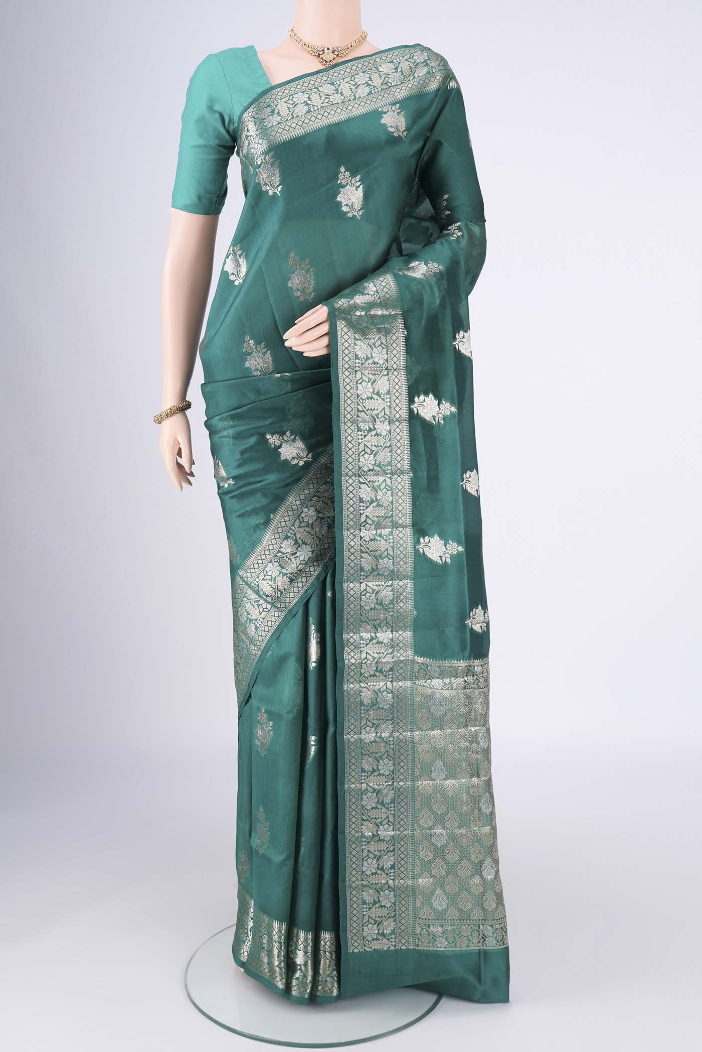 Bottle Green Banarasi Raw Silk Saree with Zari Butta on the body and Zari Border.  displayed on a mannequin