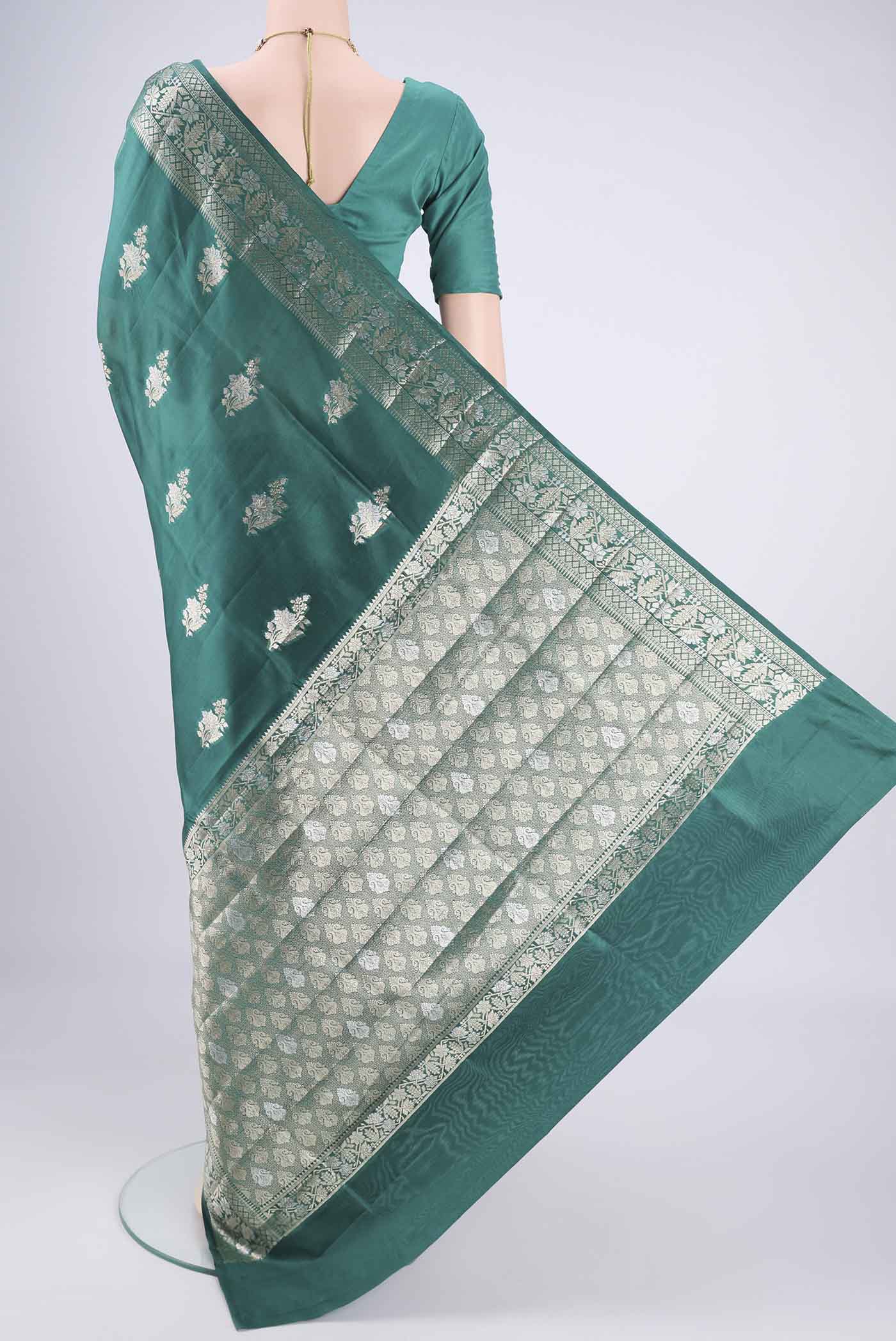 Flat view of Bottle Green Banarasi Raw Silk Saree with Zari Butta on the body and Zari Border. 