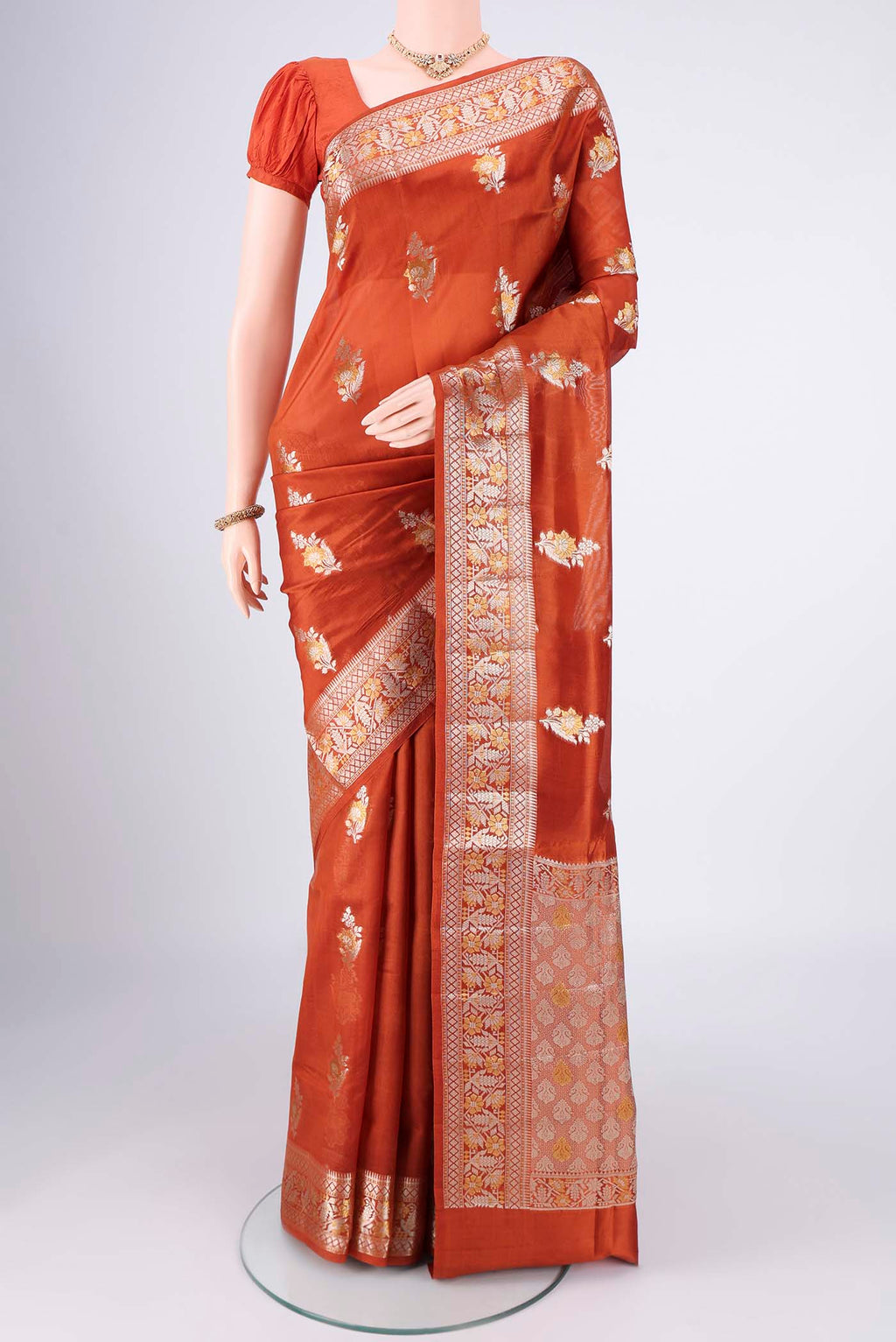 Rust Banarasi Raw Silk Saree with Zari Butta on the body and Zari Border.  displayed on a mannequin