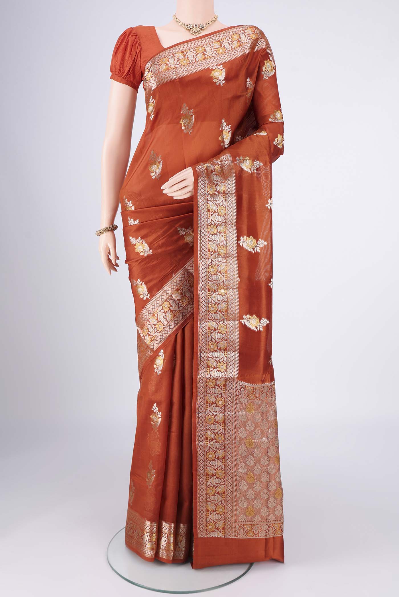 Rust Banarasi Raw Silk Saree with Zari Butta on the body and Zari Border.  displayed on a mannequin