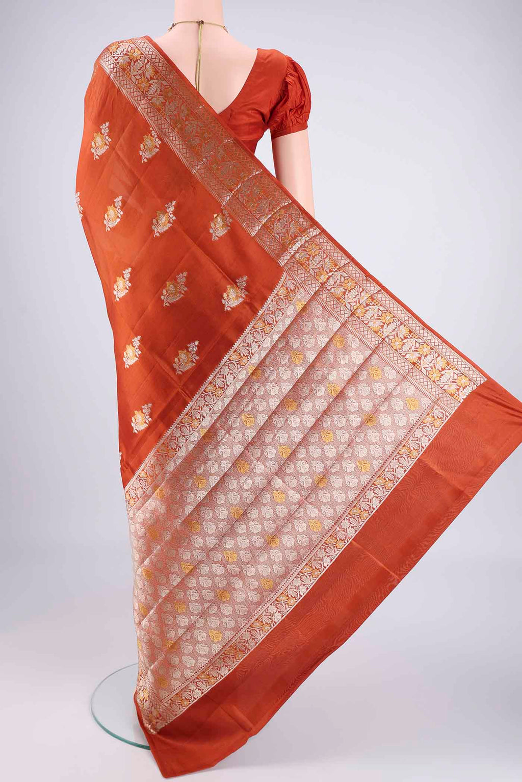 Flat view of Rust Banarasi Raw Silk Saree with Zari Butta on the body and Zari Border. 