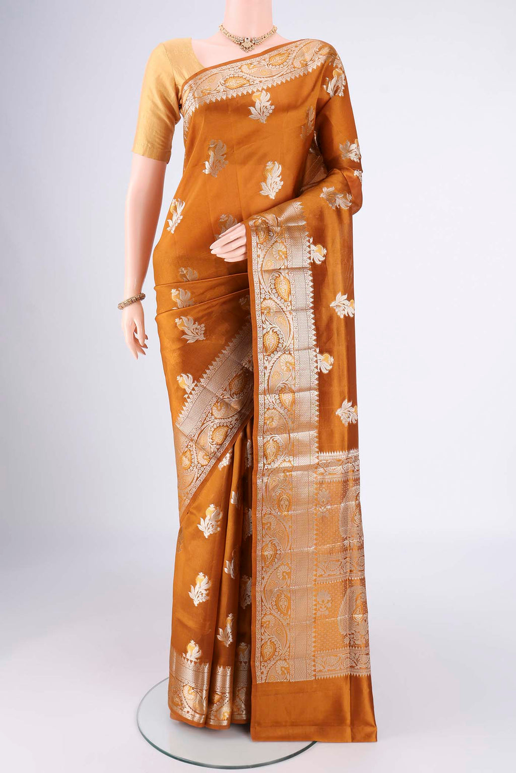 Caramel Banarasi Raw Silk Saree with Zari Butta on the body and Zari Border.  displayed on a mannequin