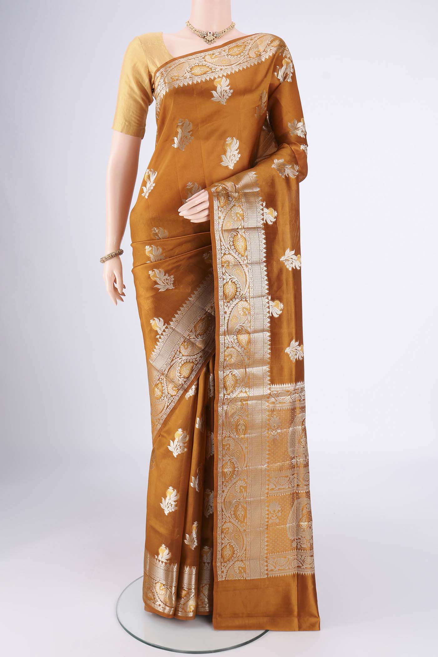 Caramel Banarasi Raw Silk Saree with Zari Butta on the body and Zari Border.  displayed on a mannequin