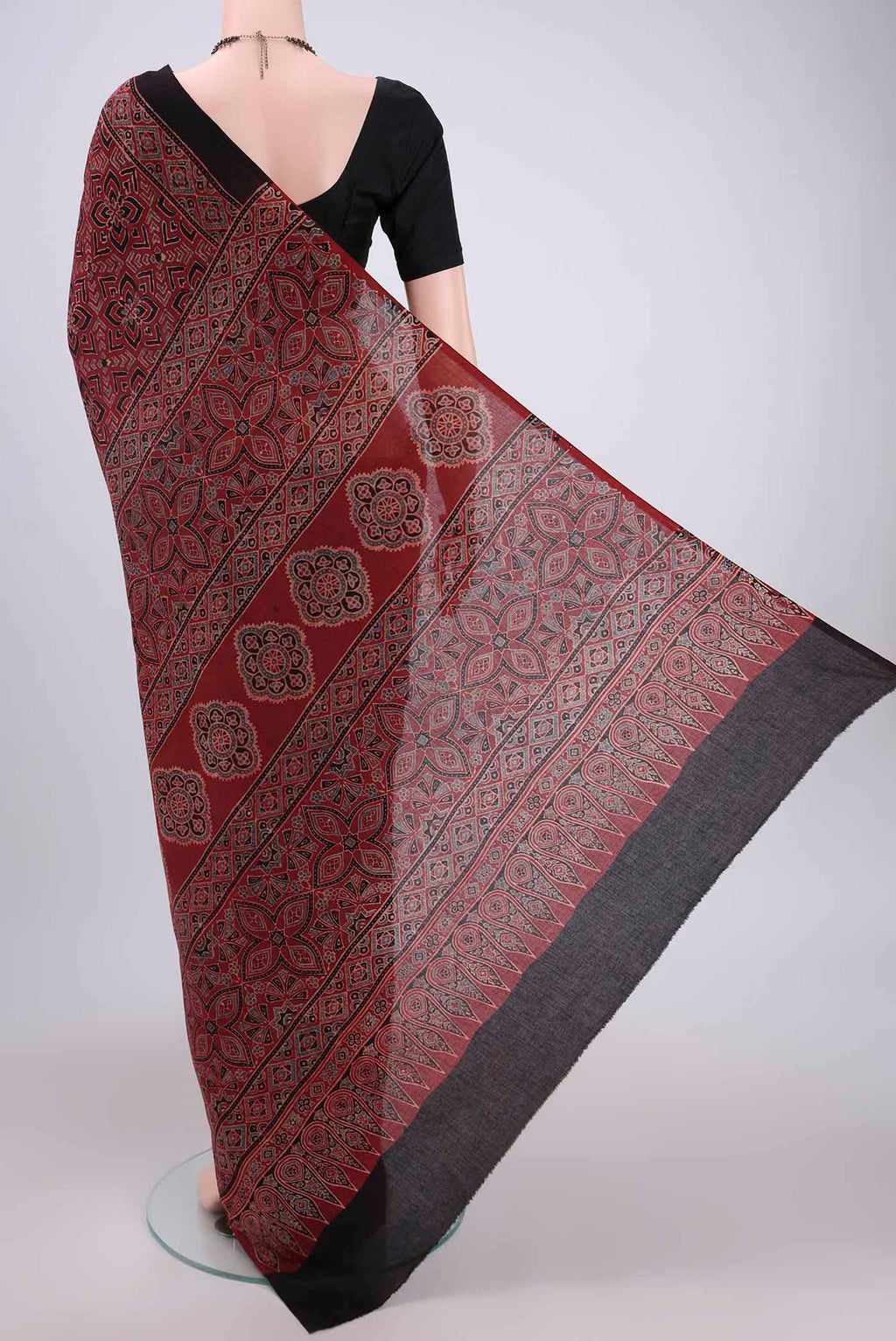 Flat view of Maroon Maheshwari Silk Cotton Saree with Ajrakh Print on the body and Plain Border. 
