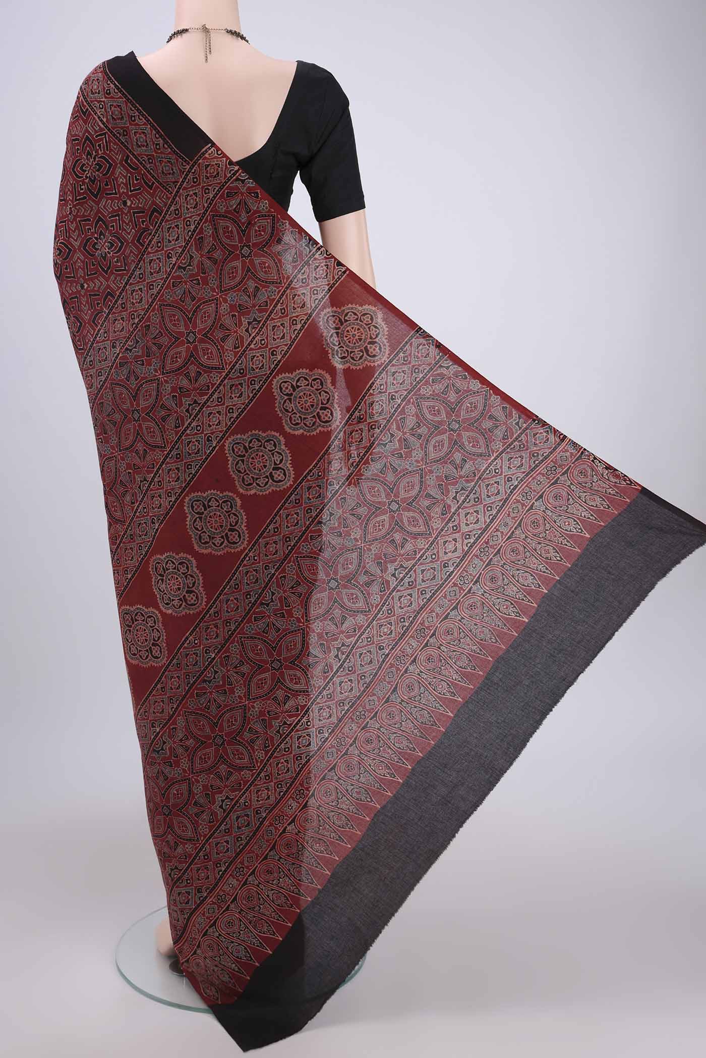 Flat view of Maroon Maheshwari Silk Cotton Saree with Ajrakh Print on the body and Plain Border. 